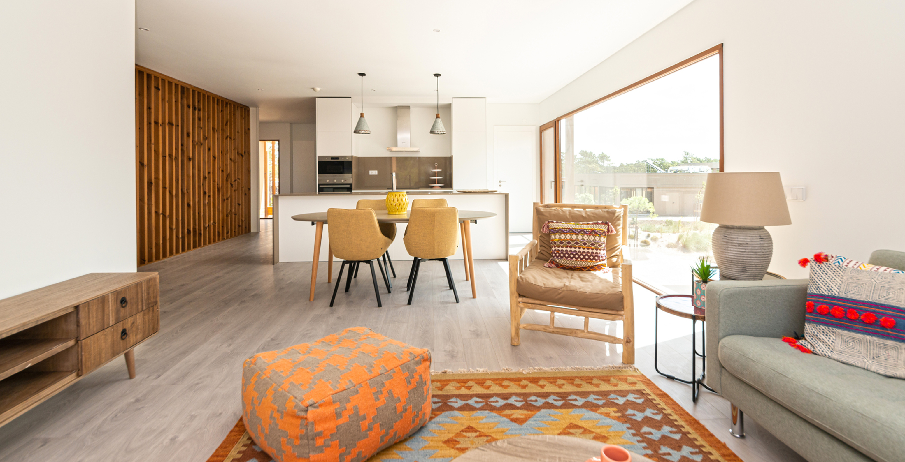O Apartamento Eco Village 1º Andar do Pestana Tróia Eco Resort tem uma sala junta com a cozinha, sofá e mesa para jantar
