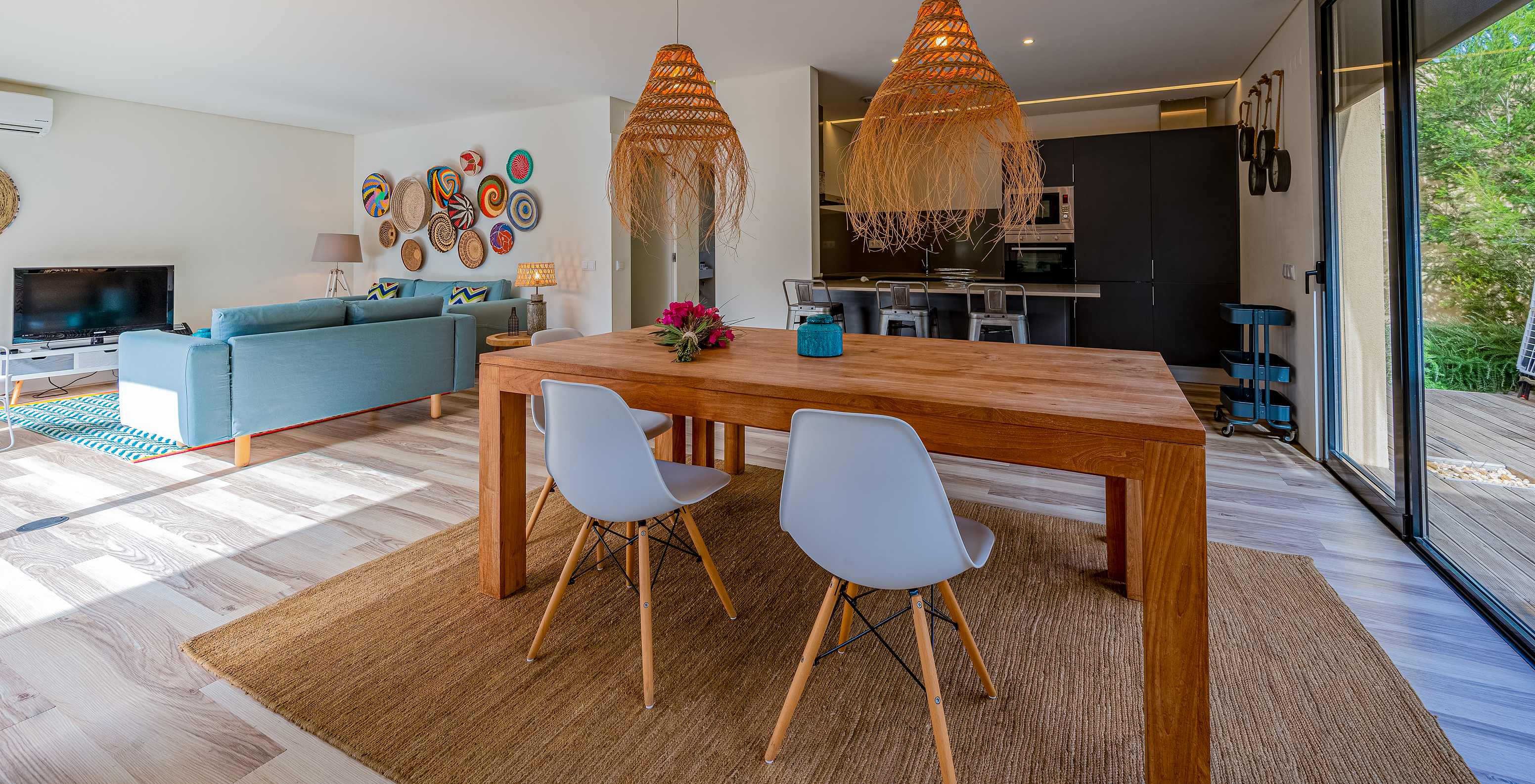 As Pine Villas do Pestana Tróia Eco Resort têm uma sala com uma mesa de madeira, candeeiros e uma cozinha
