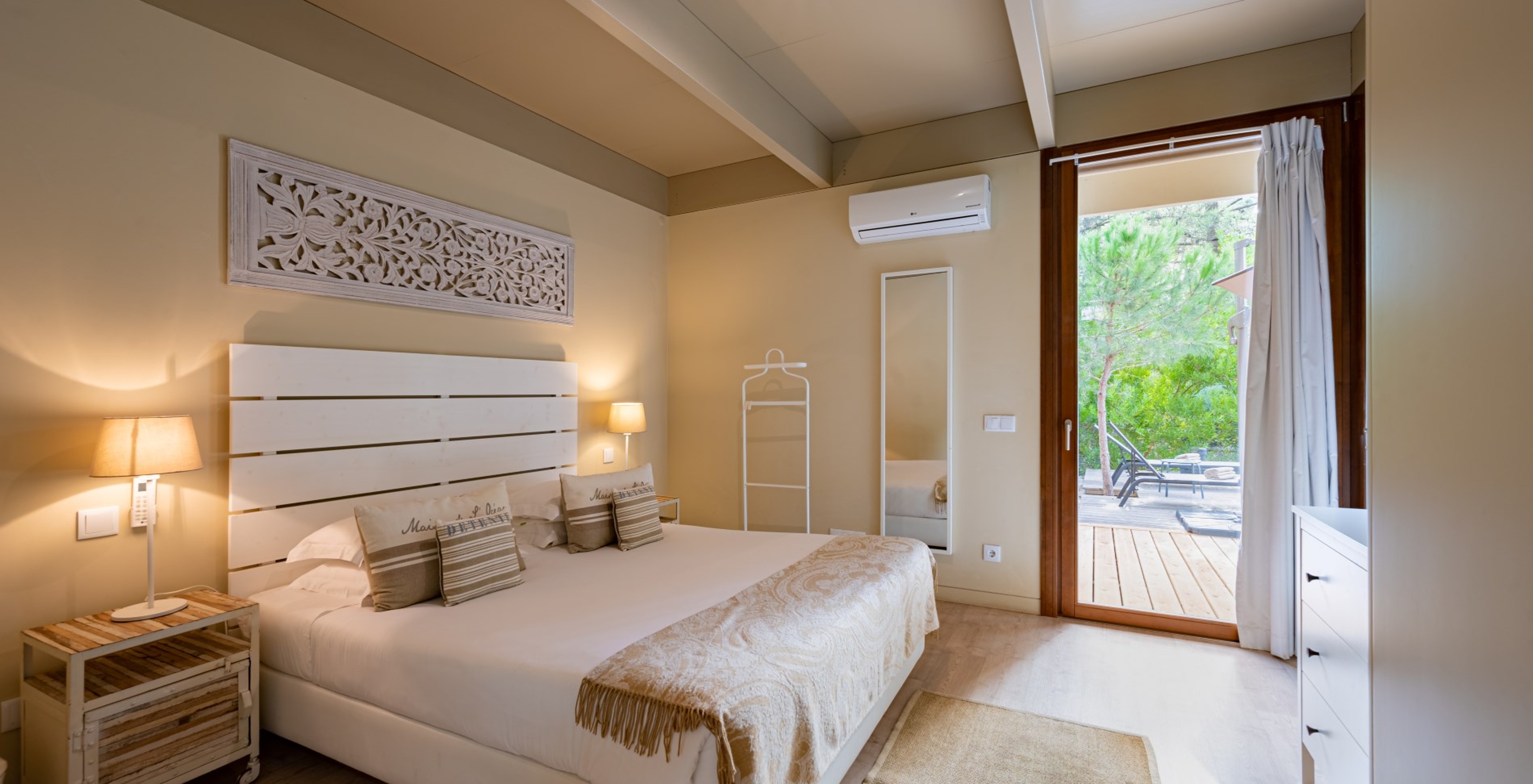 As Sand Villas com Piscina Privada do Pestana Tróia Eco Resort têm uma cama de casal com uma colcha e um espelho na parede