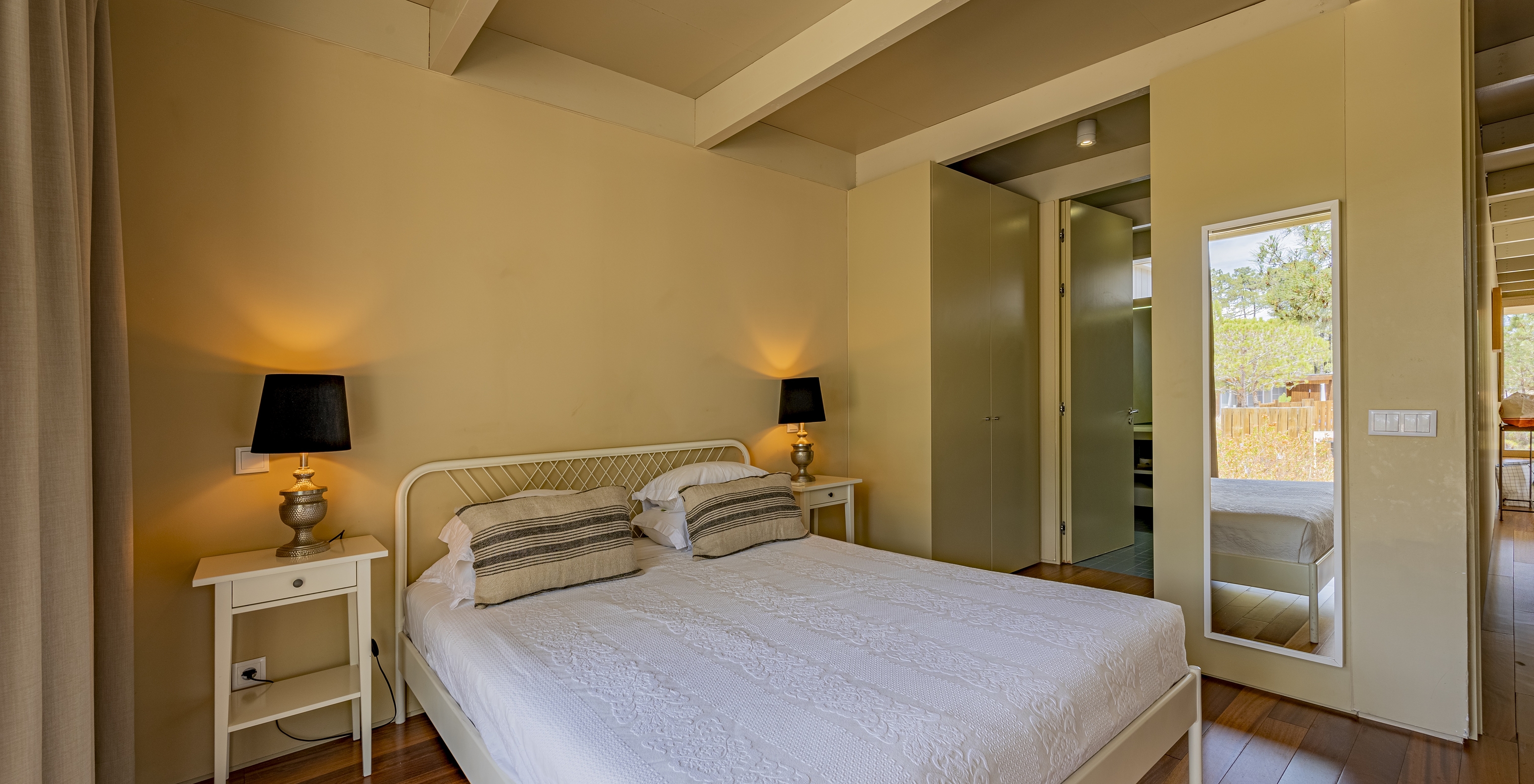 A Townhouse do Pestana Tróia Eco Resort tem uma cama de casal, duas mesas de cabeceira e um espelho na parede