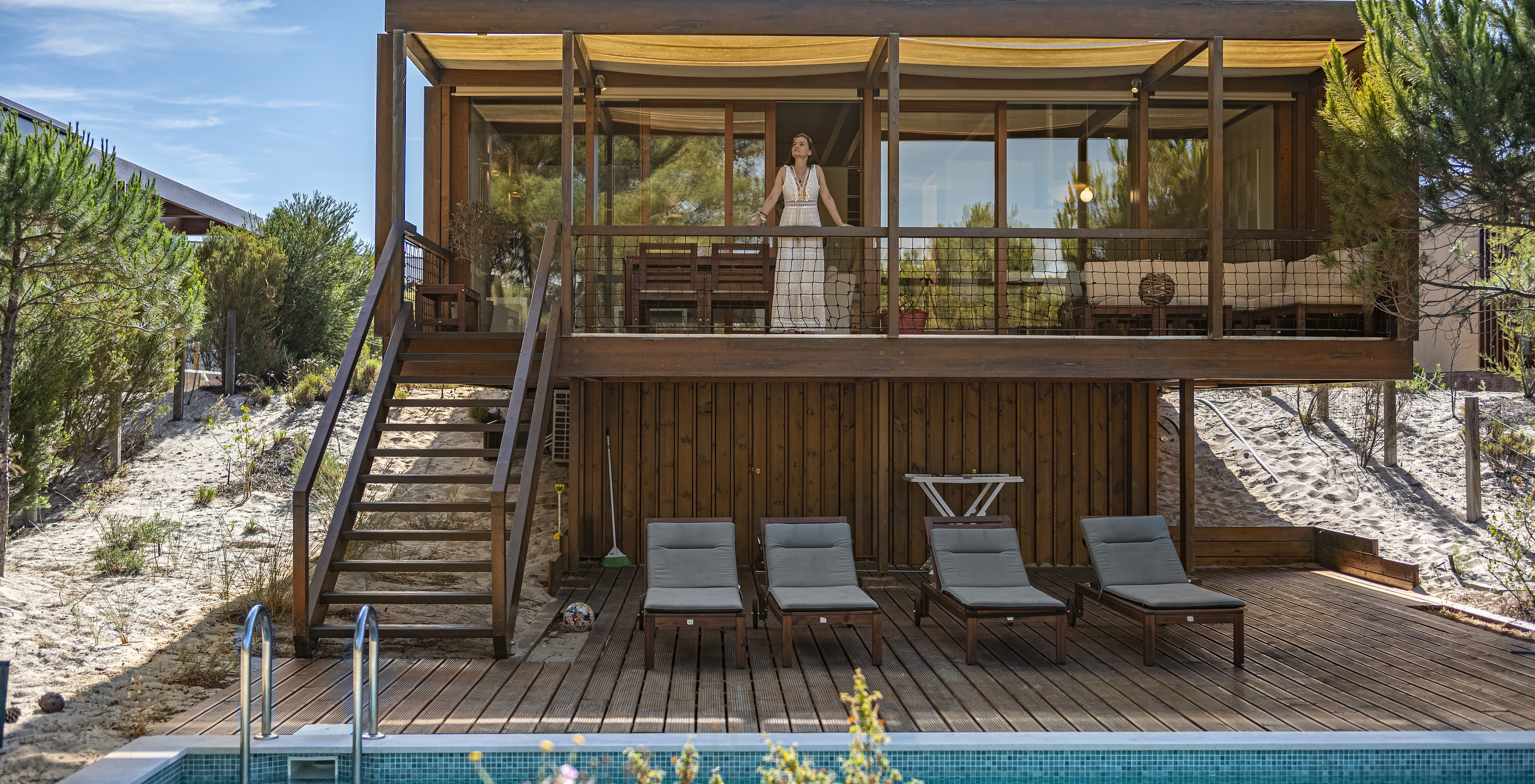 A Tree Villa com Piscina Privada do Pestana Tróia Eco Resort tem uma mulher na varanda que depois dá acesso à piscina