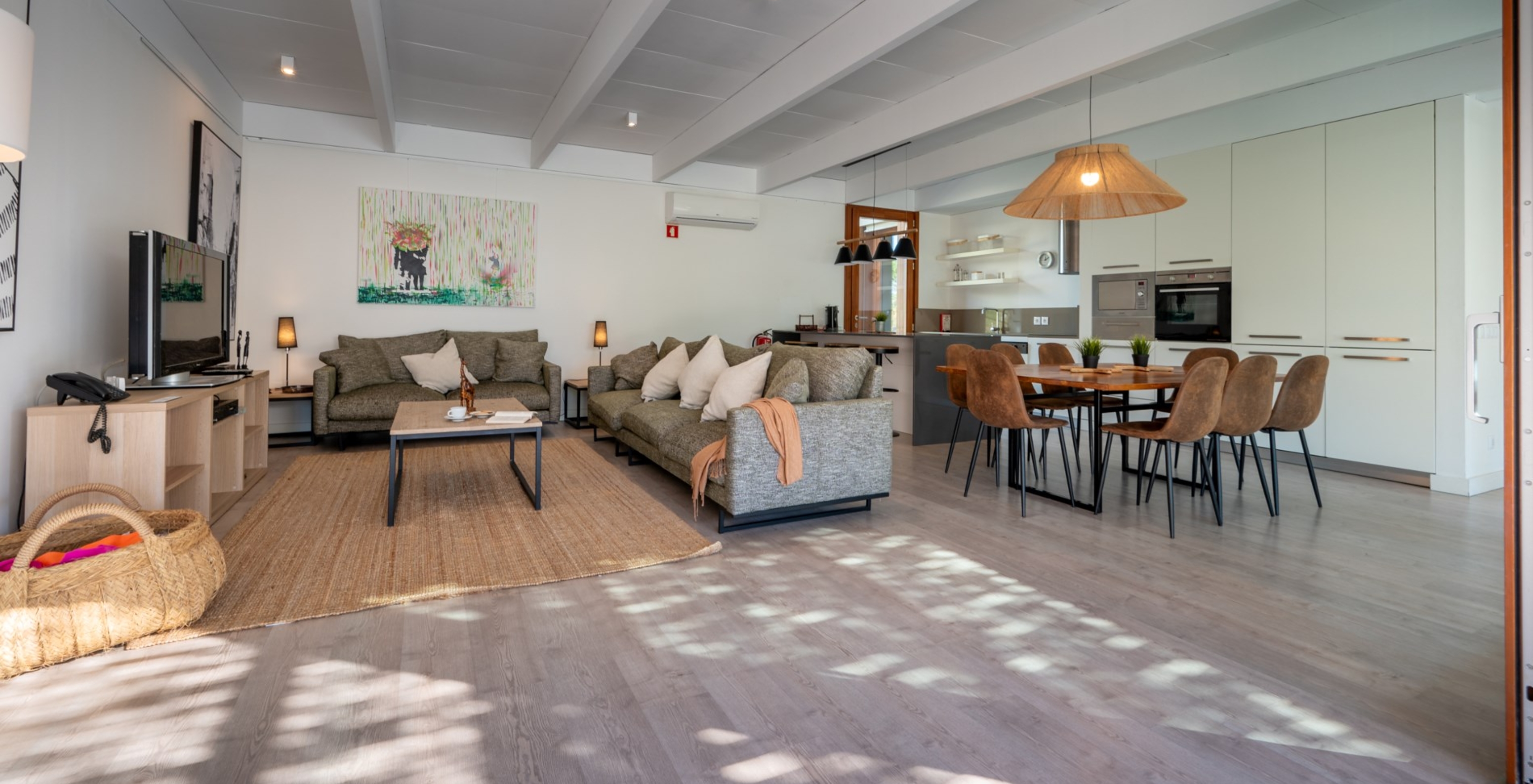 As Villas de 4 Quartos do Pestana Tróia Eco Resort têm uma grande sala de estar ligada à cozinha com sofá e mesa