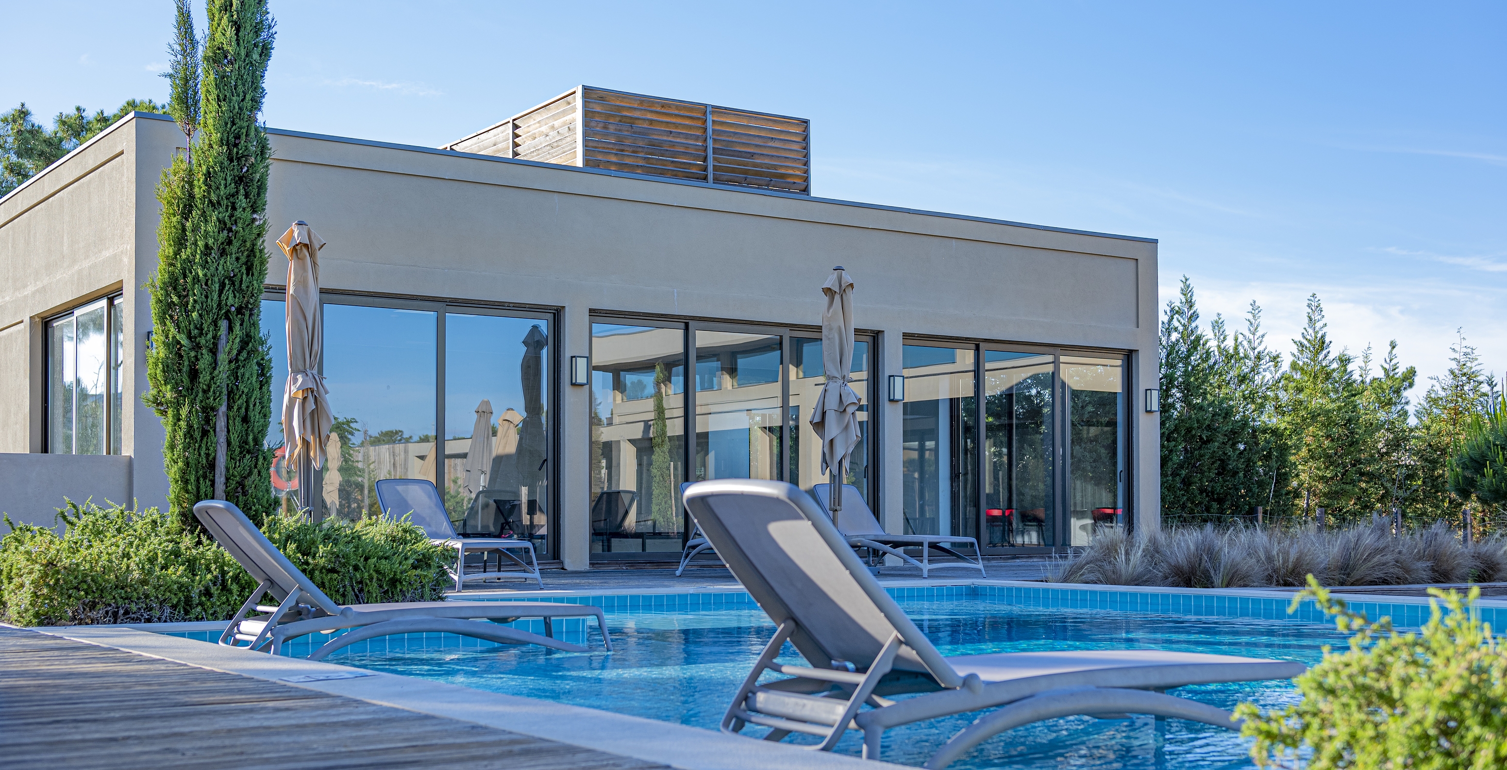 Piscina exterior no Pestana Tróia Eco Resort com duas espreguiçadeiras dentro de água, onde pode descansar