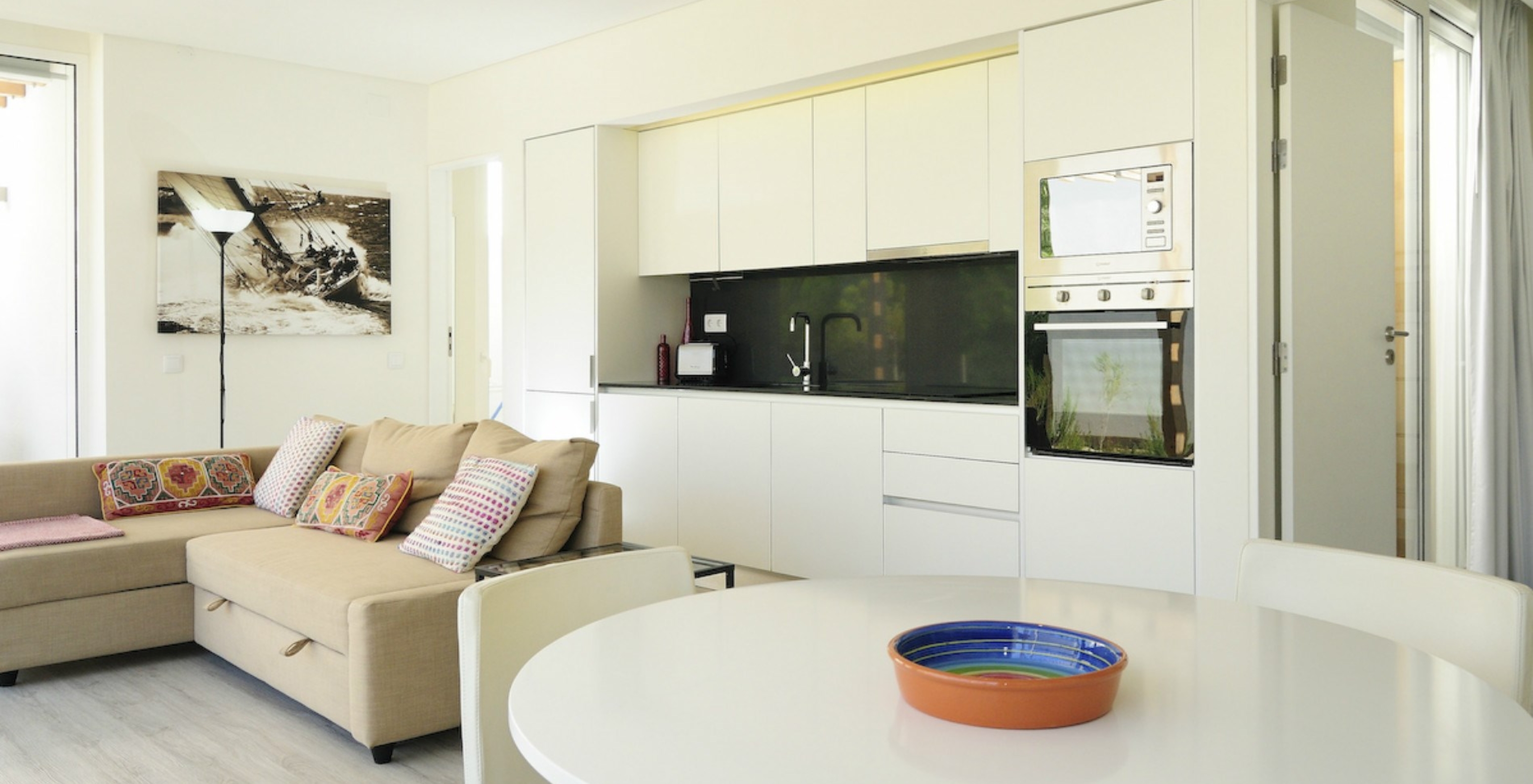 A Green Villa com Piscina Privada T3 do Pestana Tróia Eco Resort tem uma sala junta com a cozinha, sofá e mesa para jantar