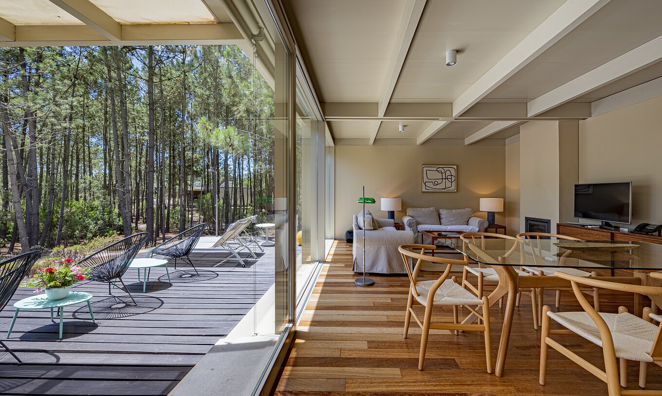 Townhouse 2 Quartos do Pestana Tróia com sala de estar luminosa, mobiliário em madeira clara e vista para pinhal através de amplas janelas