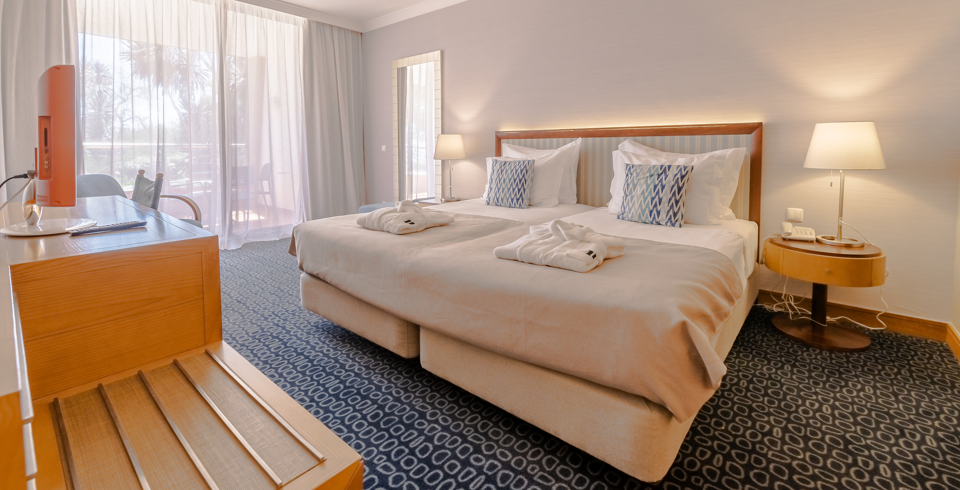 O T1 - com 1 Quarto do Pestana Alvor Park tem uma cama de casal, carpete azul e uma secretária com televisão