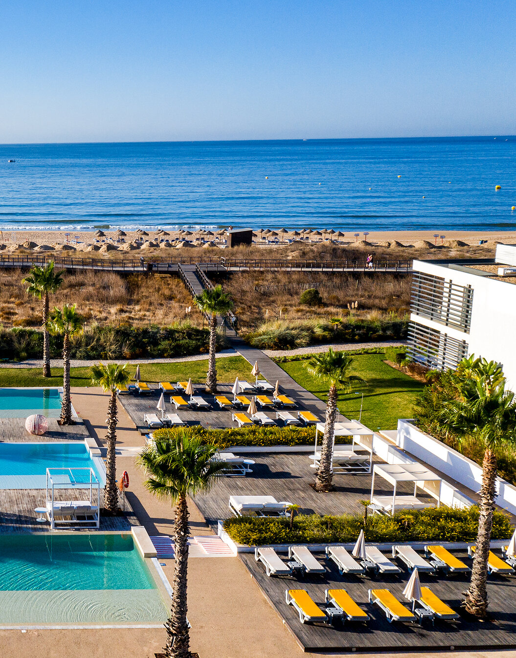 Zona exterior das piscinas e das espreguiçadeiras do Pestana Alvor South Beach, com acesso direto à praia