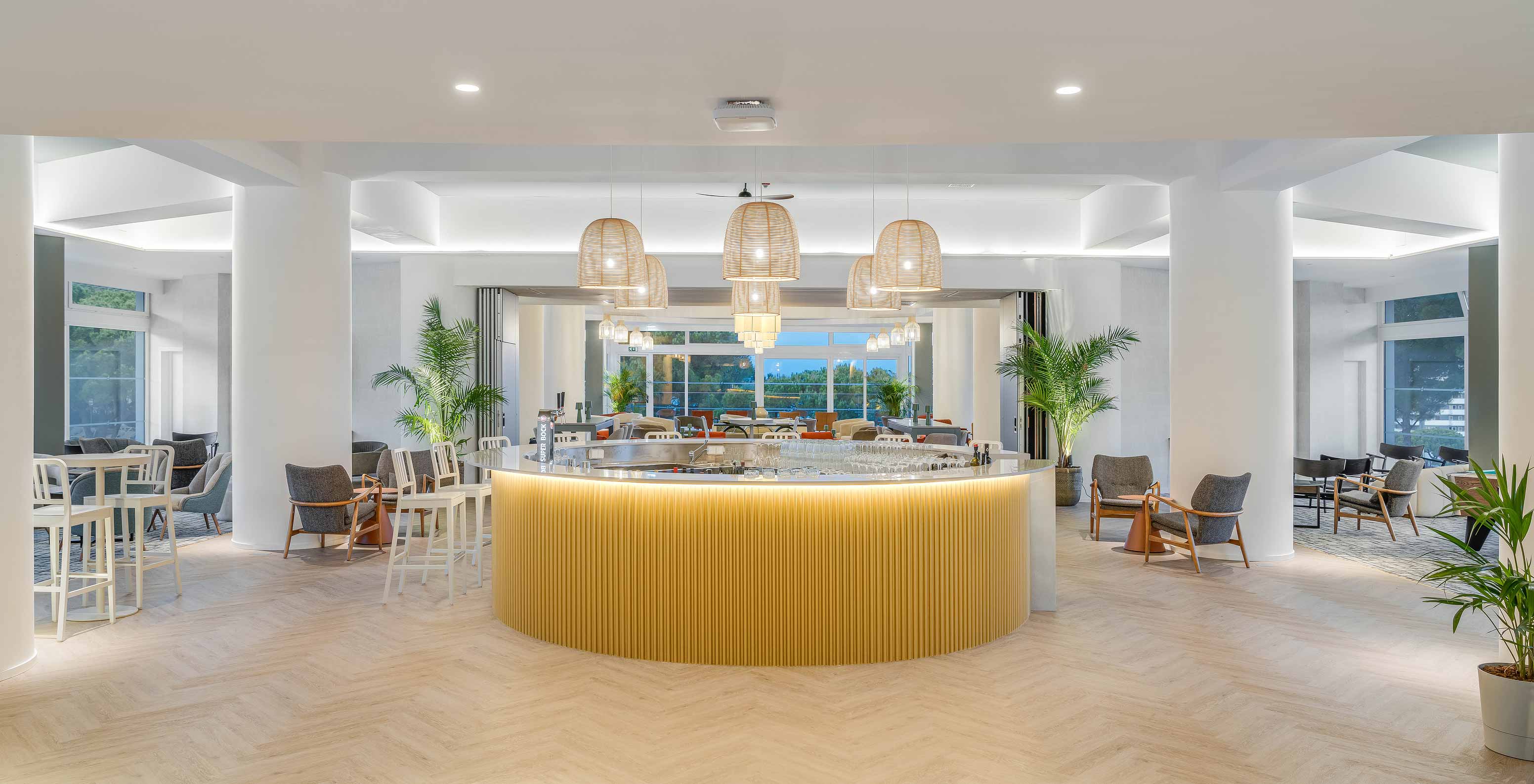 O bar Bubbles, do Hotel Tudo Incluído no Algarve, tem balcão central, luz natural e cadeiras confortáveis