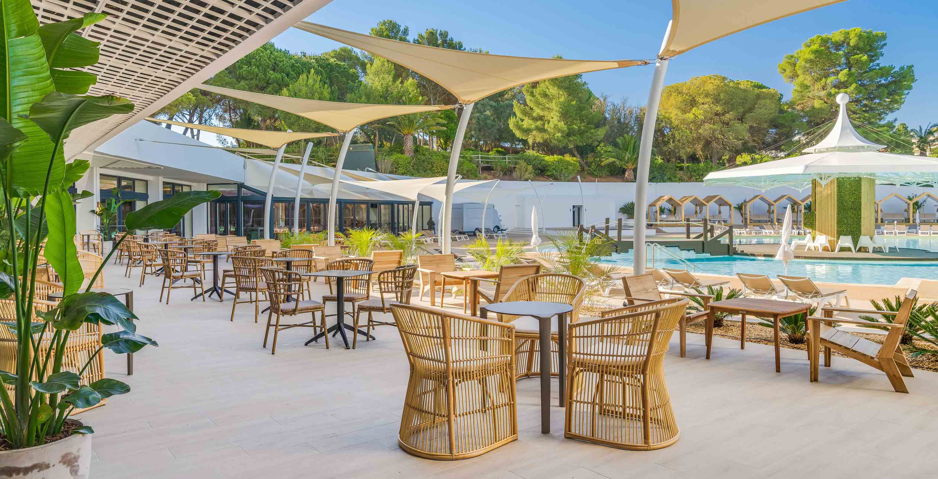 O bar Coral, do Hotel Tudo Incluído no Algarve, tem área exterior com mesas junto à piscina para beber uma bebida fresca.