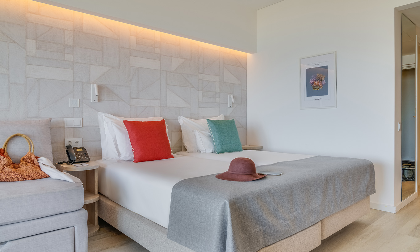 O Quarto Familiar do Pestana Blue Alvor Beach tem duas camas individuais, um quadro e um espelho grande na parede