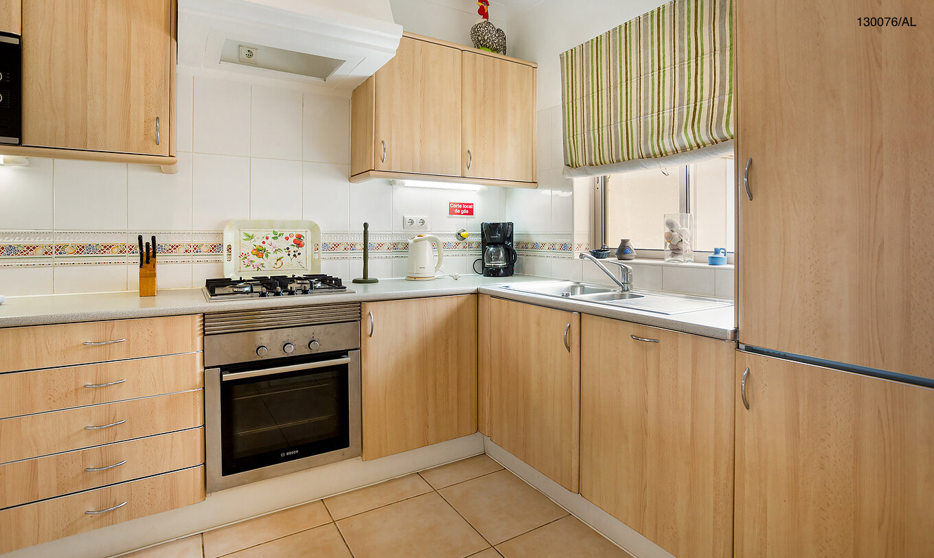 O Apartamento T2 Standart do Pestana Carvoeiro Golfe tem uma cozinha equipada com armários de madeira e eletrodomésticos