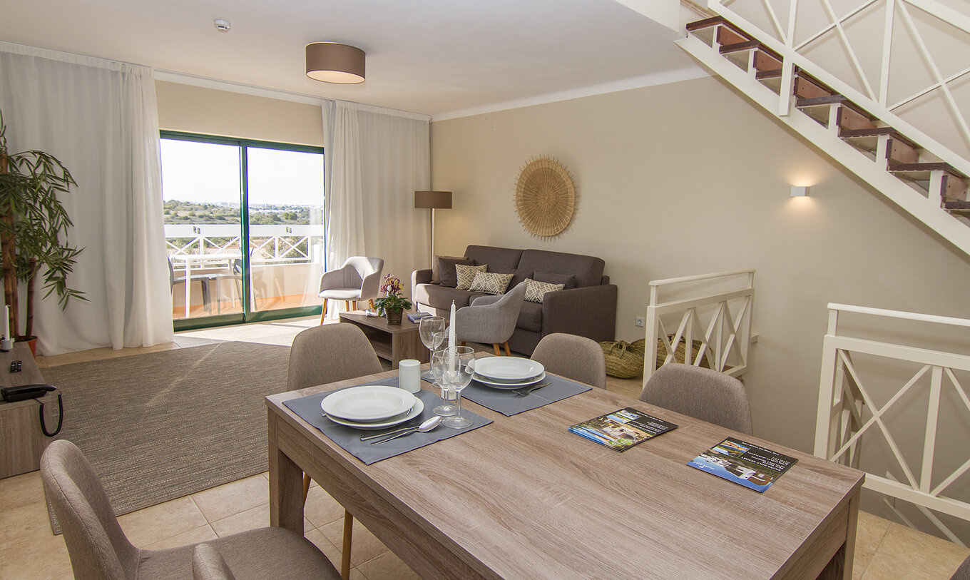 O Apartamento T2 do Pestana Gramacho Residences tem uma sala de estar com mesa com cadeiras para refeições e um sofá