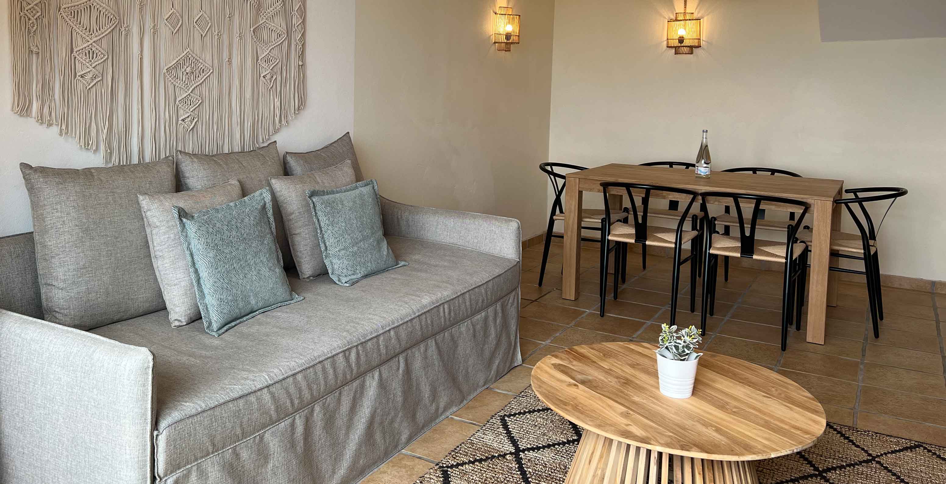 Premium com 2 Quartos no Pestana Palm Gardens, sala com sofá bege, mesa de madeira e cadeiras pretas