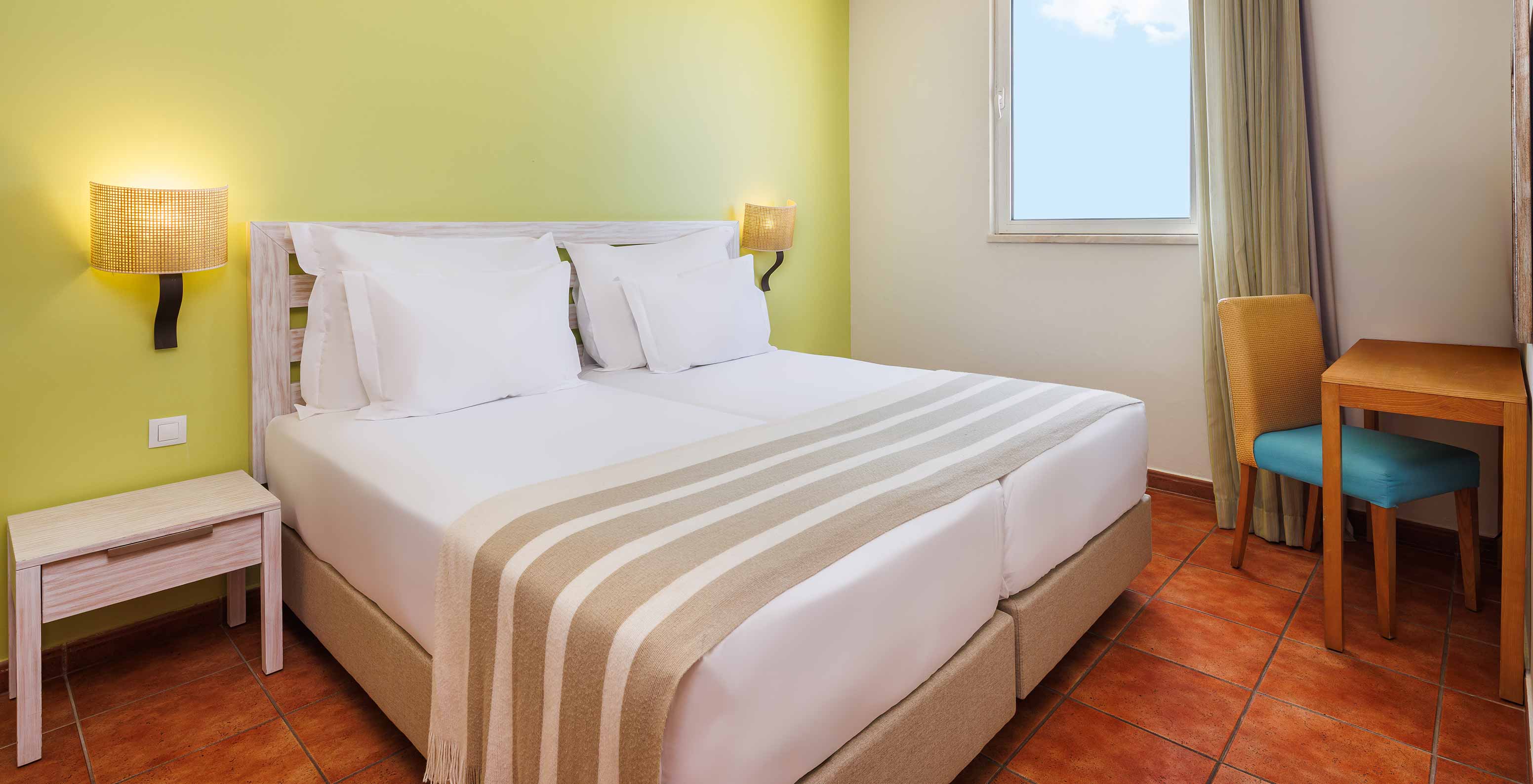Suite Superior com Vista Mar no Pestana Viking com cama de casal, secretária junto à janela e iluminação suave