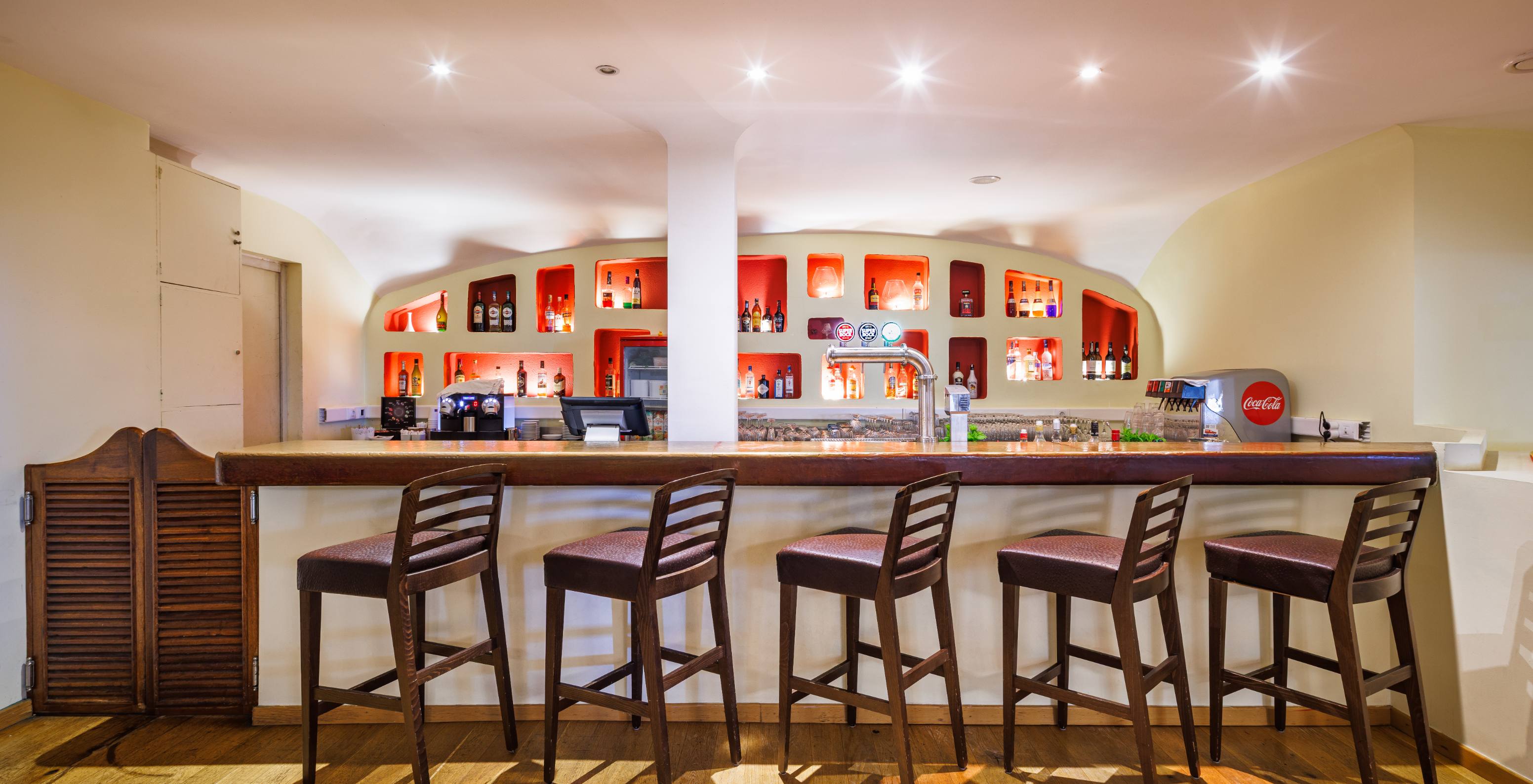 Bar do Pestana Viking Hotel com Piscina em Armação de Pêra, com balcão em madeira e prateleiras iluminadas