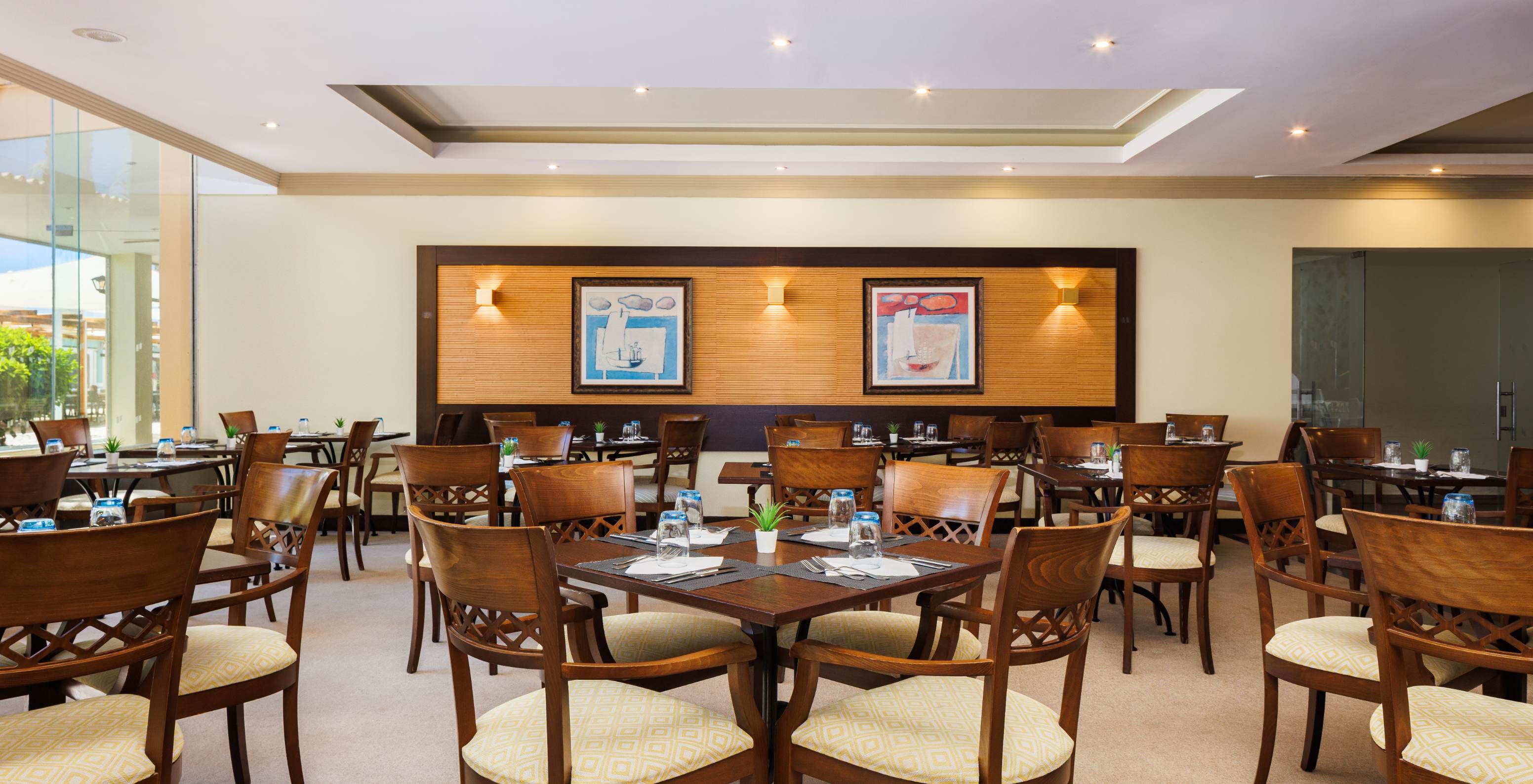 Restaurante do Pestana Viking Hotel com Piscina em Armação de Pêra, sala com mesas de madeira iluminada