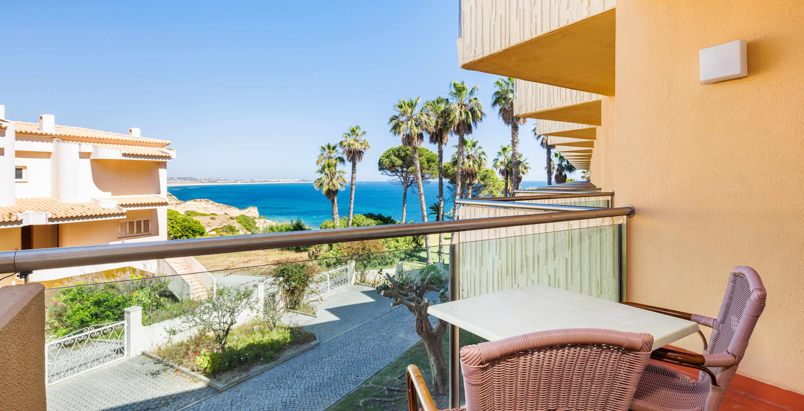 Quarto Deluxe com Vista Mar e Varanda no Pestana Viking, varanda mobilada com vista para o mar e palmeiras