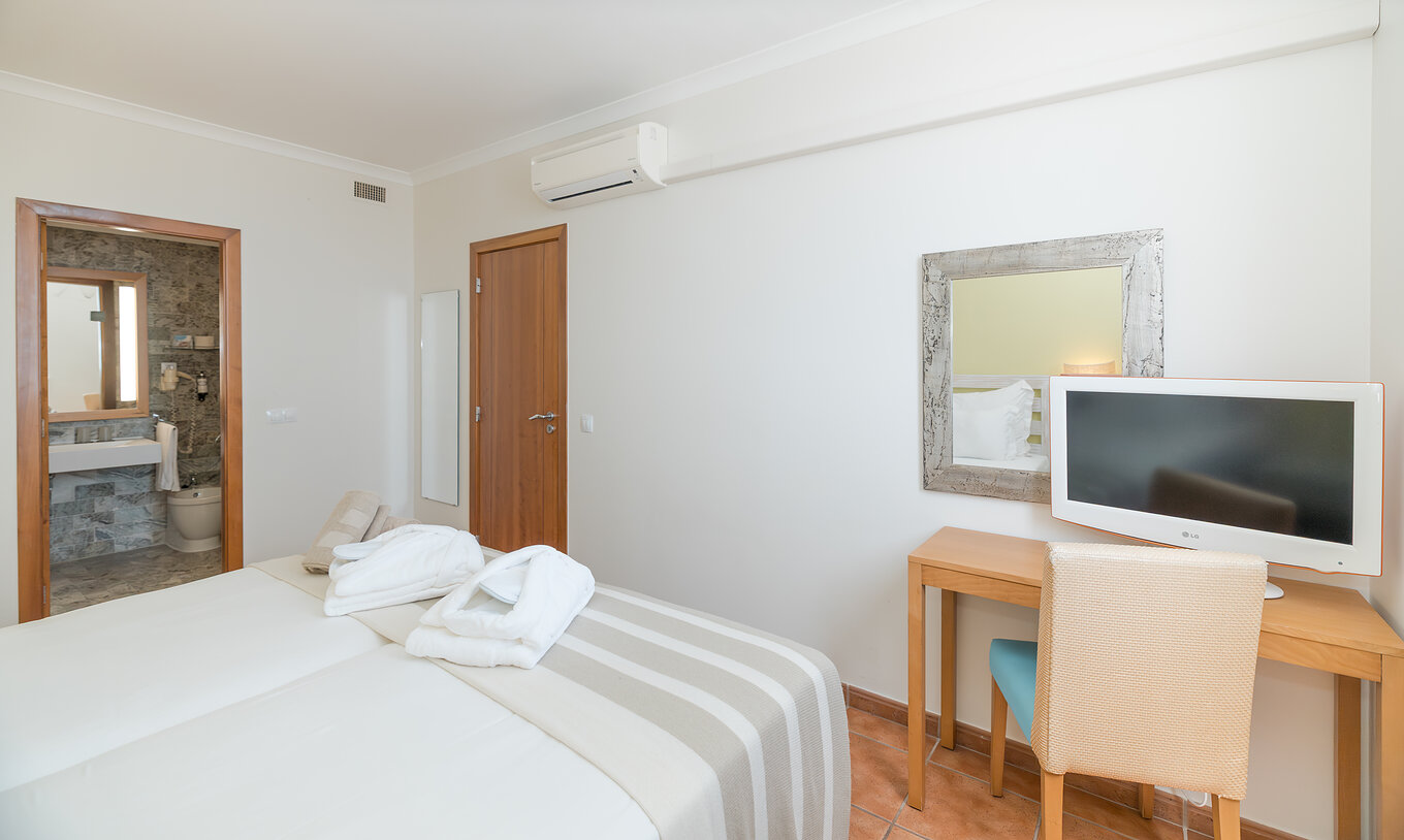 A Suite Vista Mar do Pestana Viking tem um quarto com duas camas, ar condicionado, secretária e casa de banho