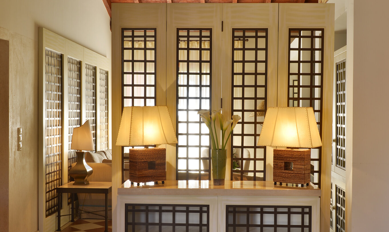 A Suite Vista Jardim Vila Sol do Pestana Vila Sol - Vilamoura tem uma entrada com uma mesa com dois candeeiros e um jarro