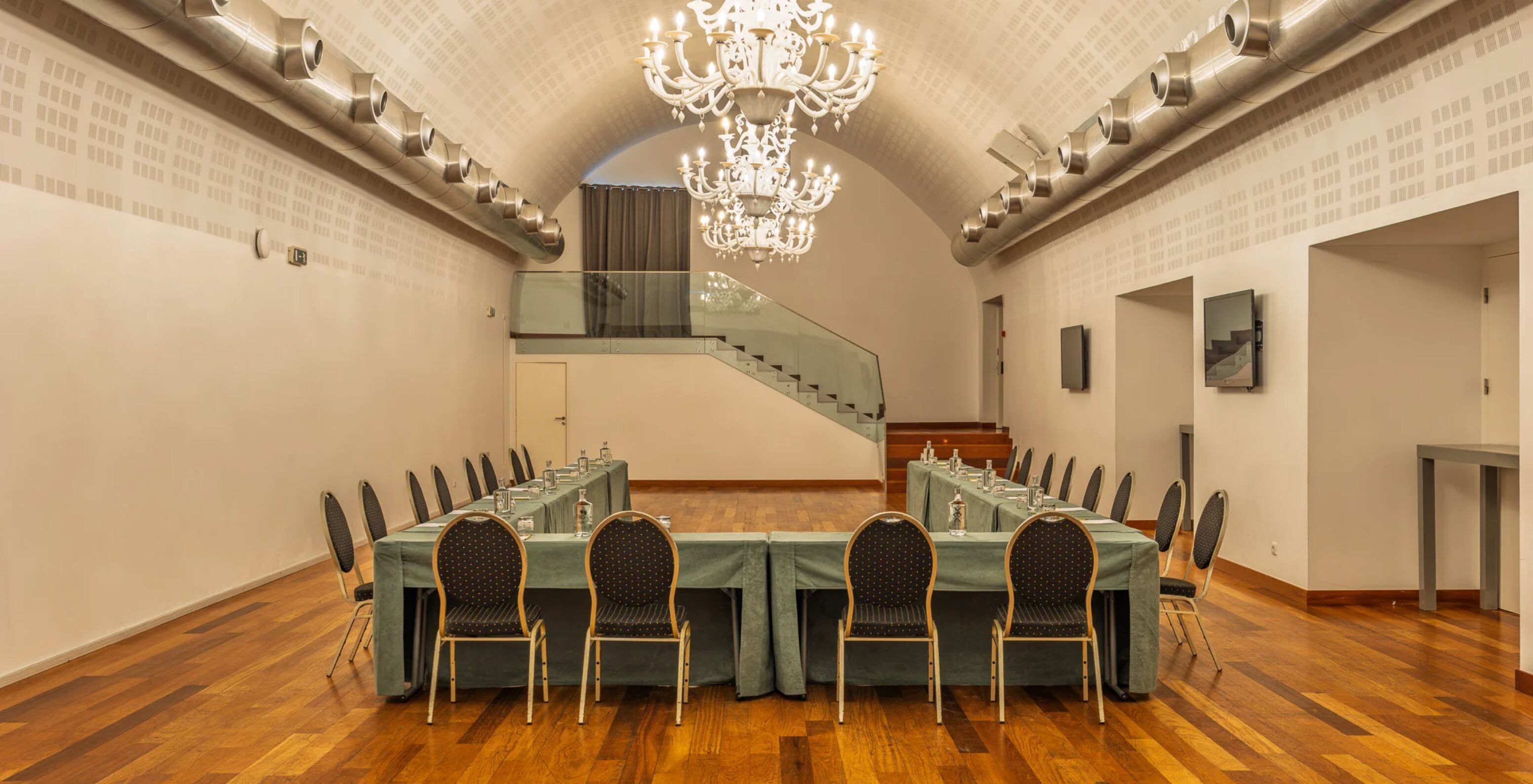 Hotel Pestana Cidadela Cascais com sala de reuniões ampla, mesas em U, lustres brancos e chão em madeira