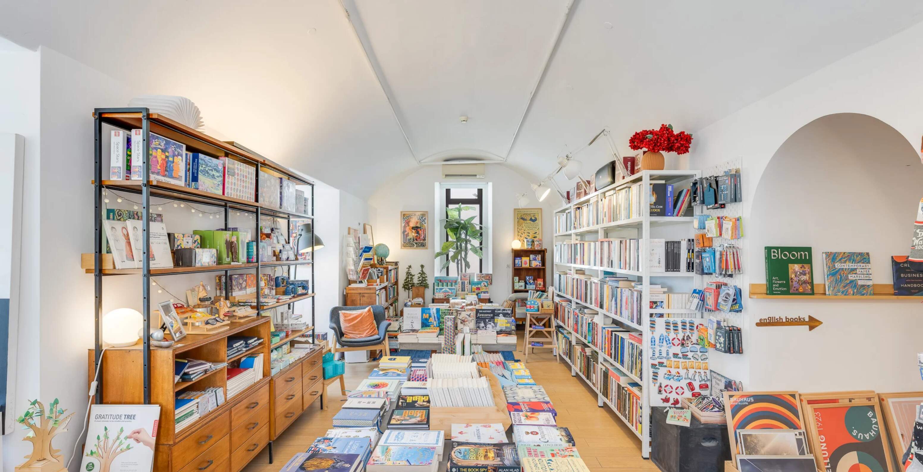 Livraria independente perto do Pestana Cidadela Cascais com estantes altas, mesas de livros e luz natural