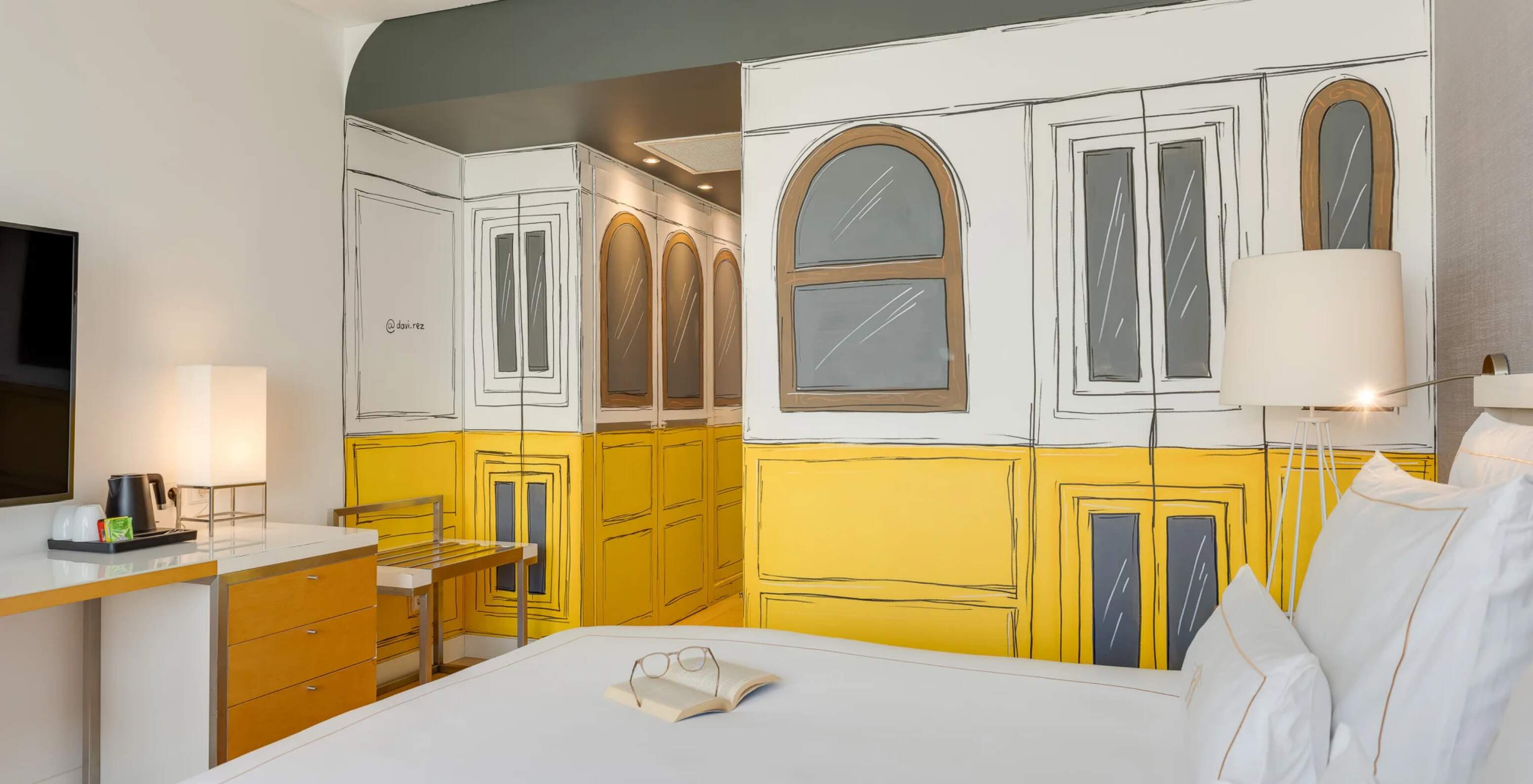 Pestana Cidadela Cascais Hotel 5 Estrelas em Cascais, com quarto moderno e mural artístico amarelo nas paredes