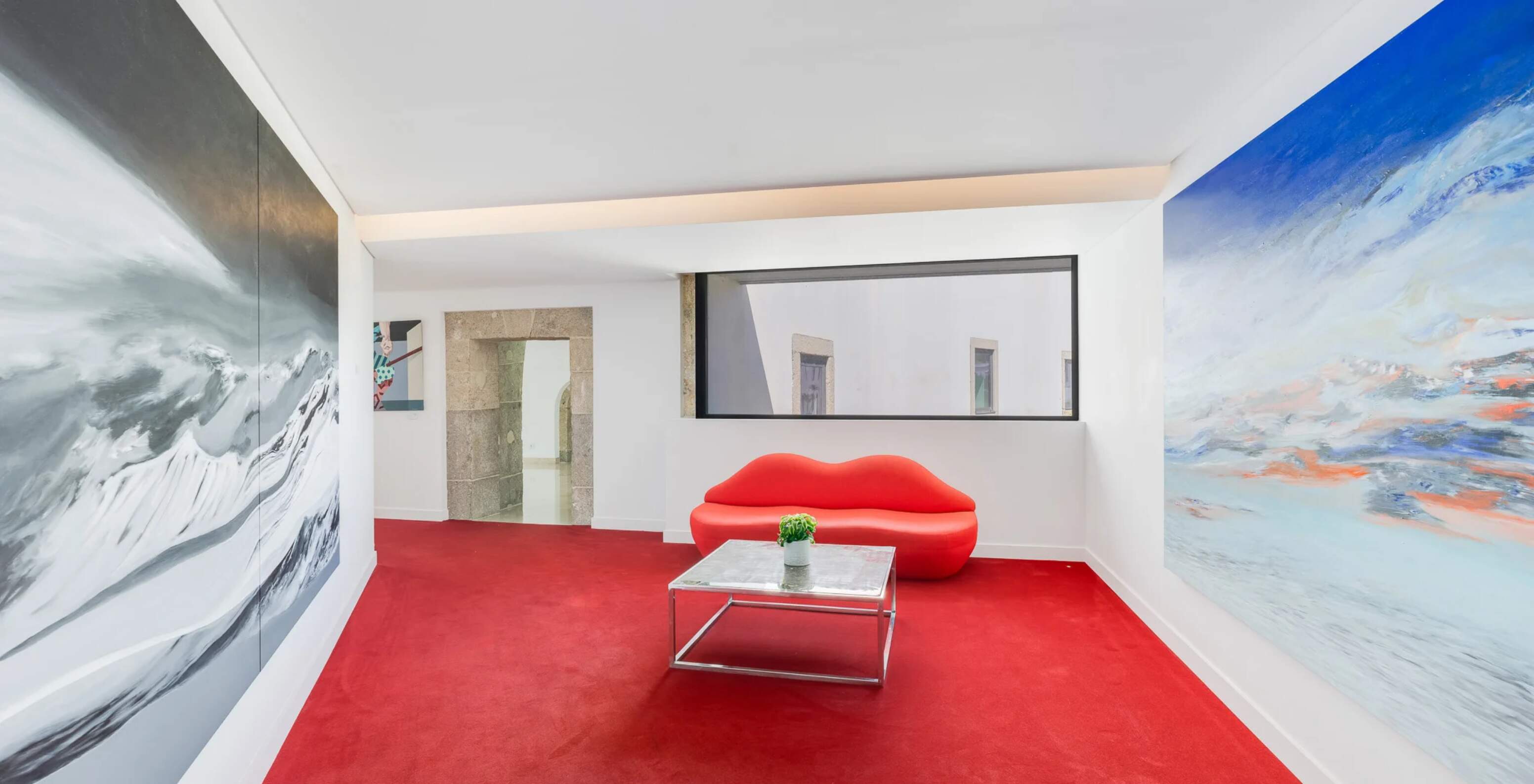 Pestana Cidadela Cascais Hotel 5 Estrelas em Cascais, corredor moderno com sofá vermelho e pinturas abstratas