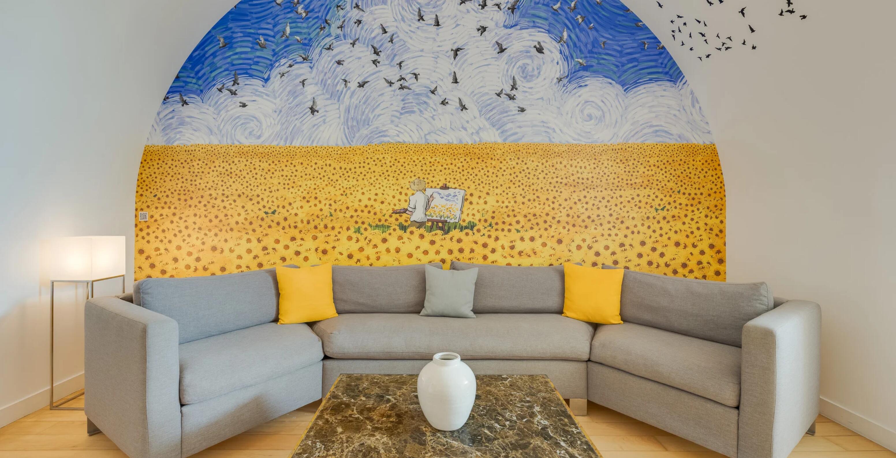 Suite Júnior Art District no Pestana Cidadela Cascais com sofá cinzento e mural amarelo artístico