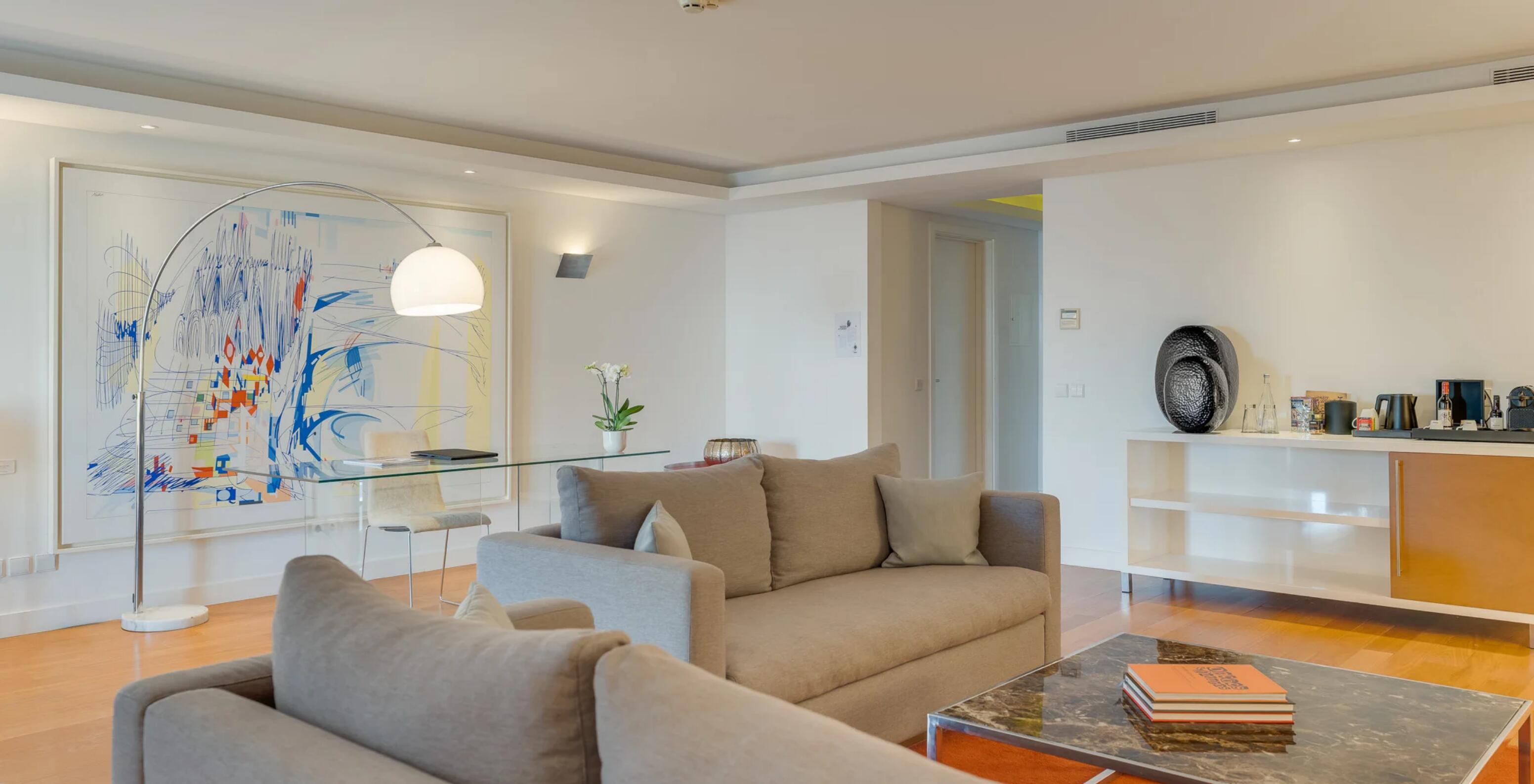 Suite Presidencial no Pestana Cidadela Cascais com sofá bege, mesa de vidro e decoração contemporânea