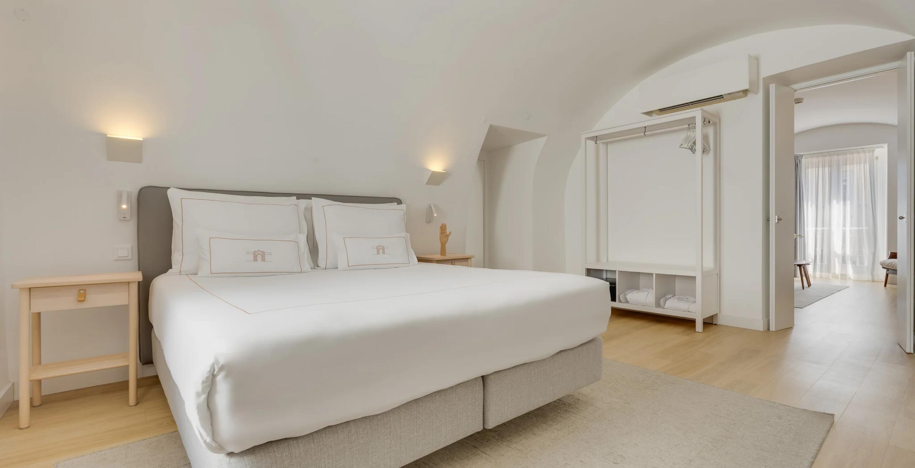 Suite Praça de Armas no Pestana Cidadela Cascais com cama de casal, teto arqueado e decoração clara minimalista