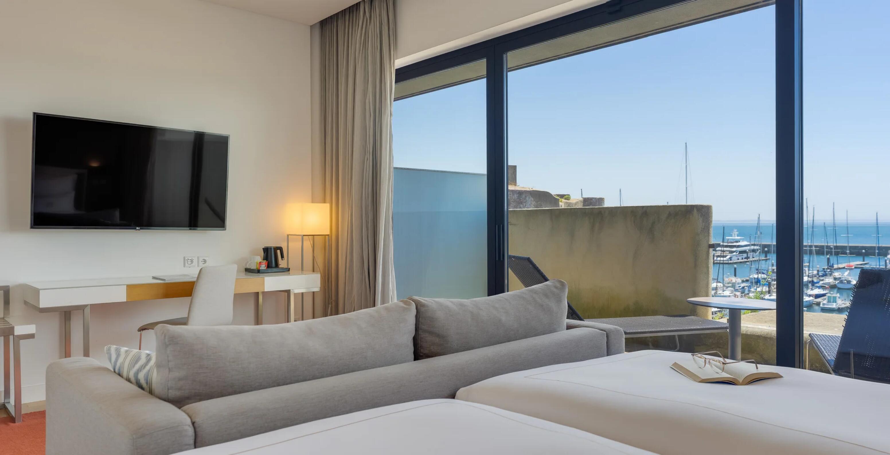 Quarto Duplo Superior com Vista Mar no Pestana Cidadela Cascais, com sofá e varanda sobre a marina
