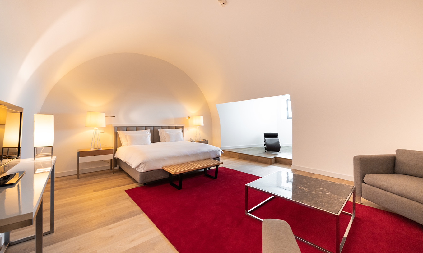 A Junior Suite Familiar do Pestana Cidadela Cascais é ampla e tem um teto alto, uma cama de casal e uma secretária