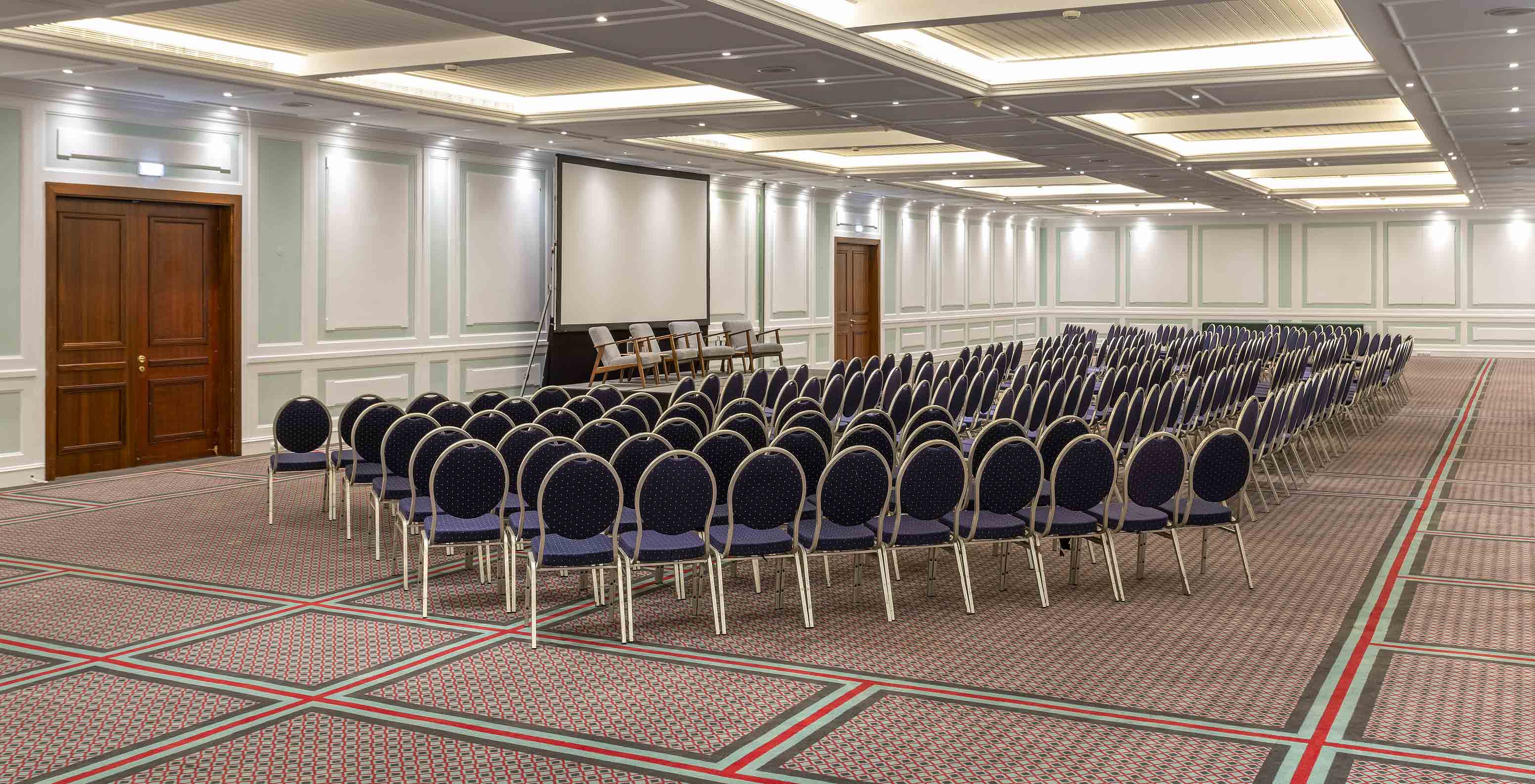 O Pestana Palace Lisboa tem uma sala grande de reuniões e eventos coberta com tapete e com cadeiras azuis