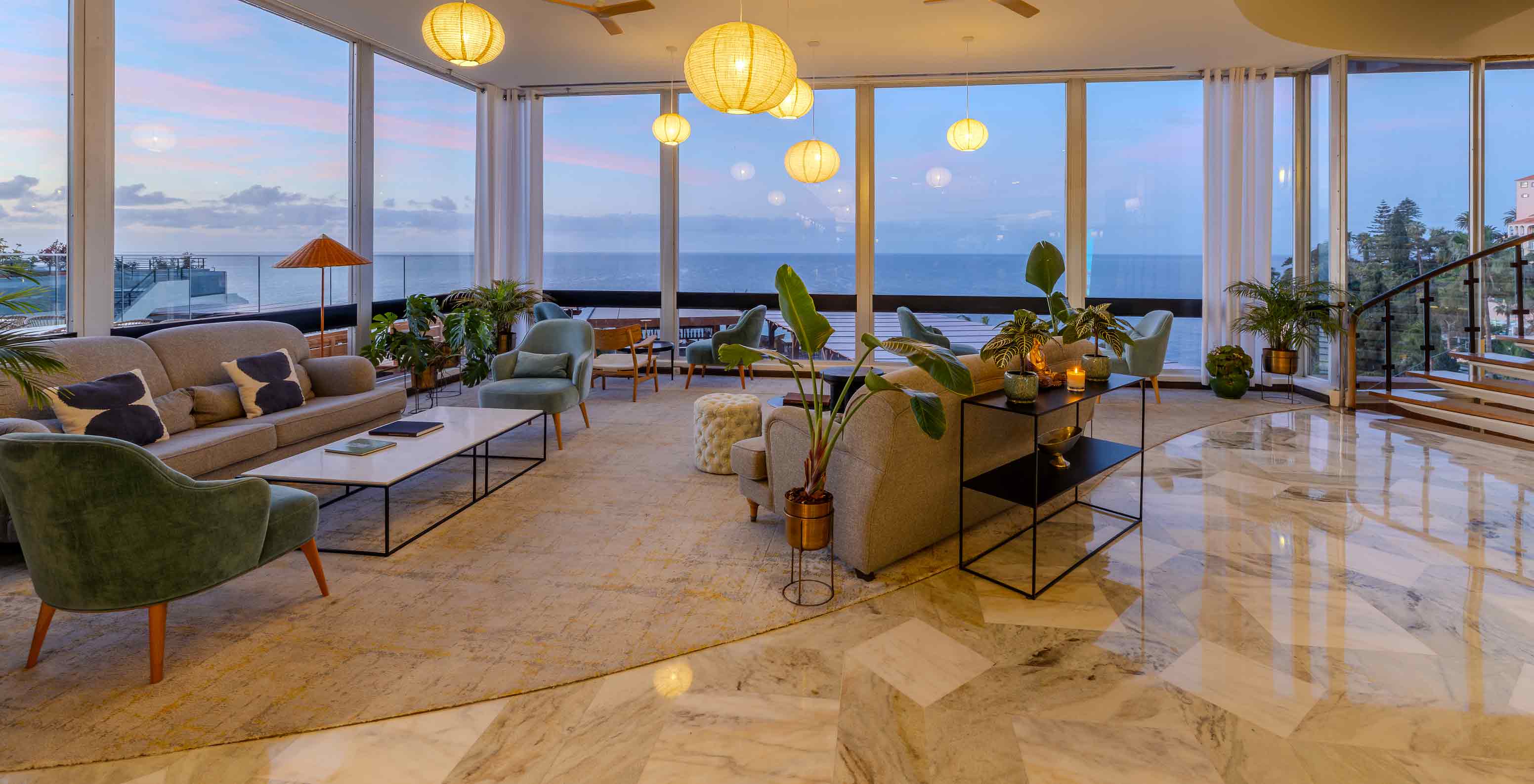Pestana Carlton Madeira, Hotel 5 Estrelas na Madeira, lobby com sofás elegantes e vista mar ao entardecer