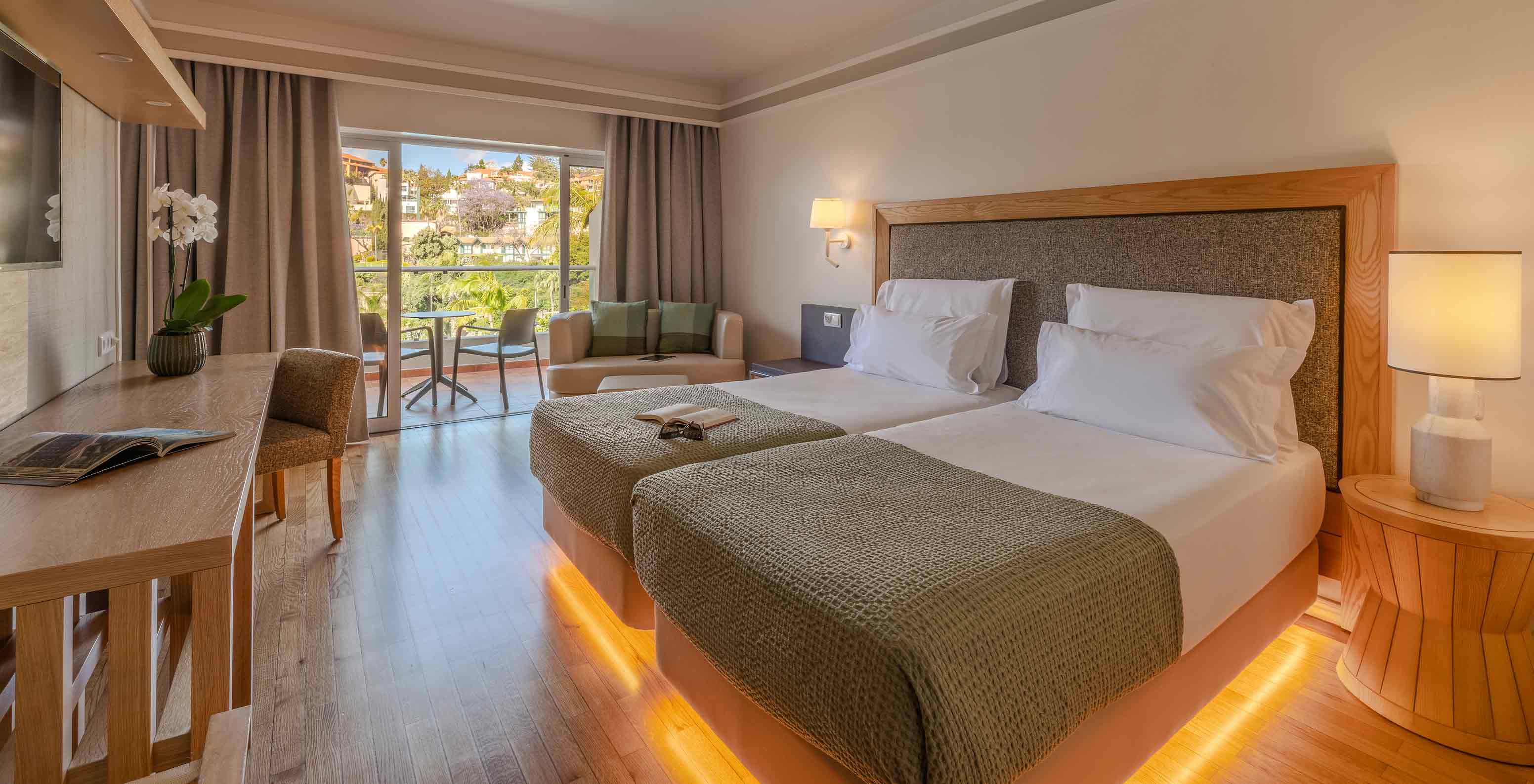 Pestana Carlton Madeira Hotel 5 Estrelas na Madeira, quarto luminoso com varanda e camas junto à janela