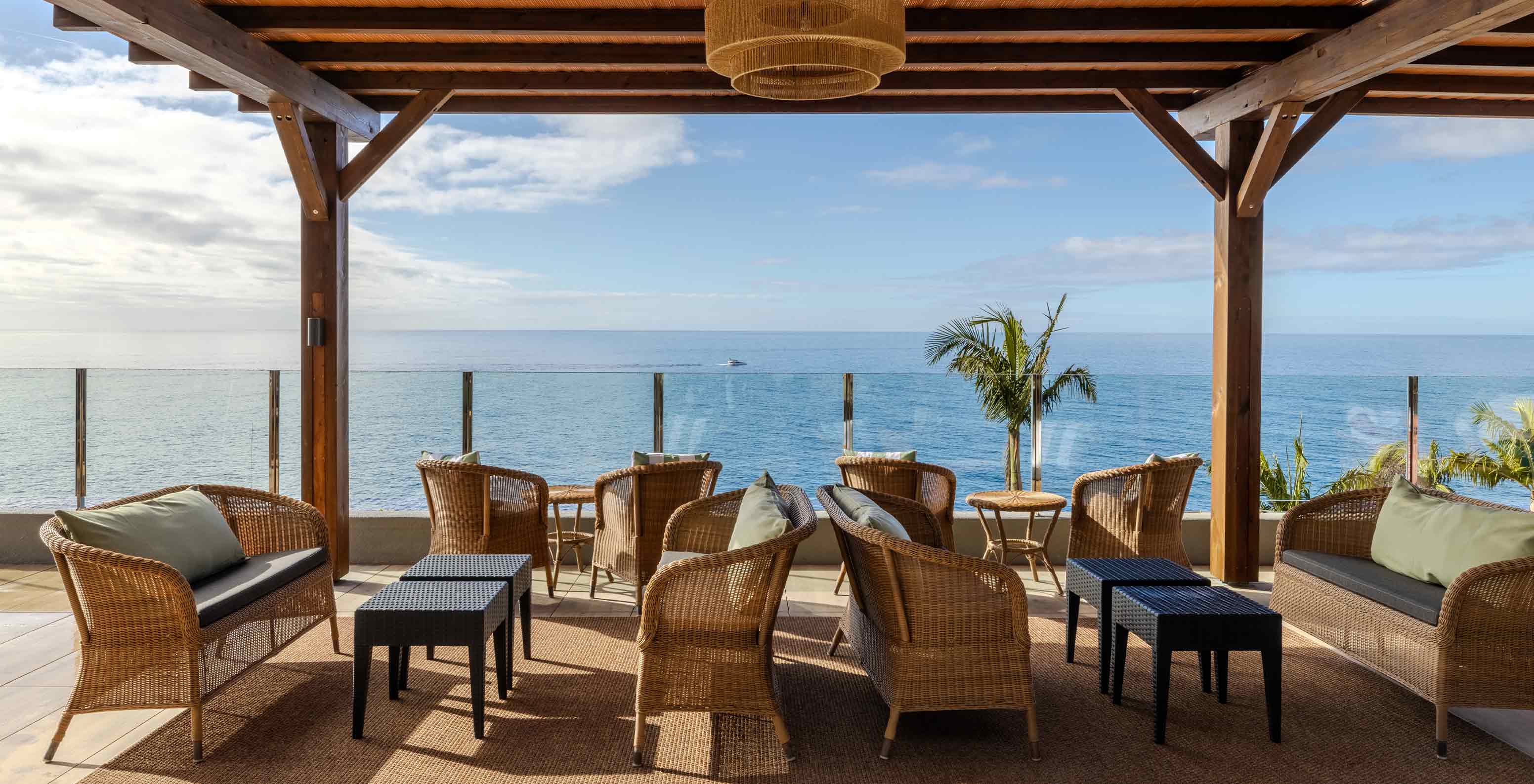 Pestana Carlton Madeira Hotel 5 Estrelas na Madeira, terraço coberto com cadeiras e vista para o Atlântico