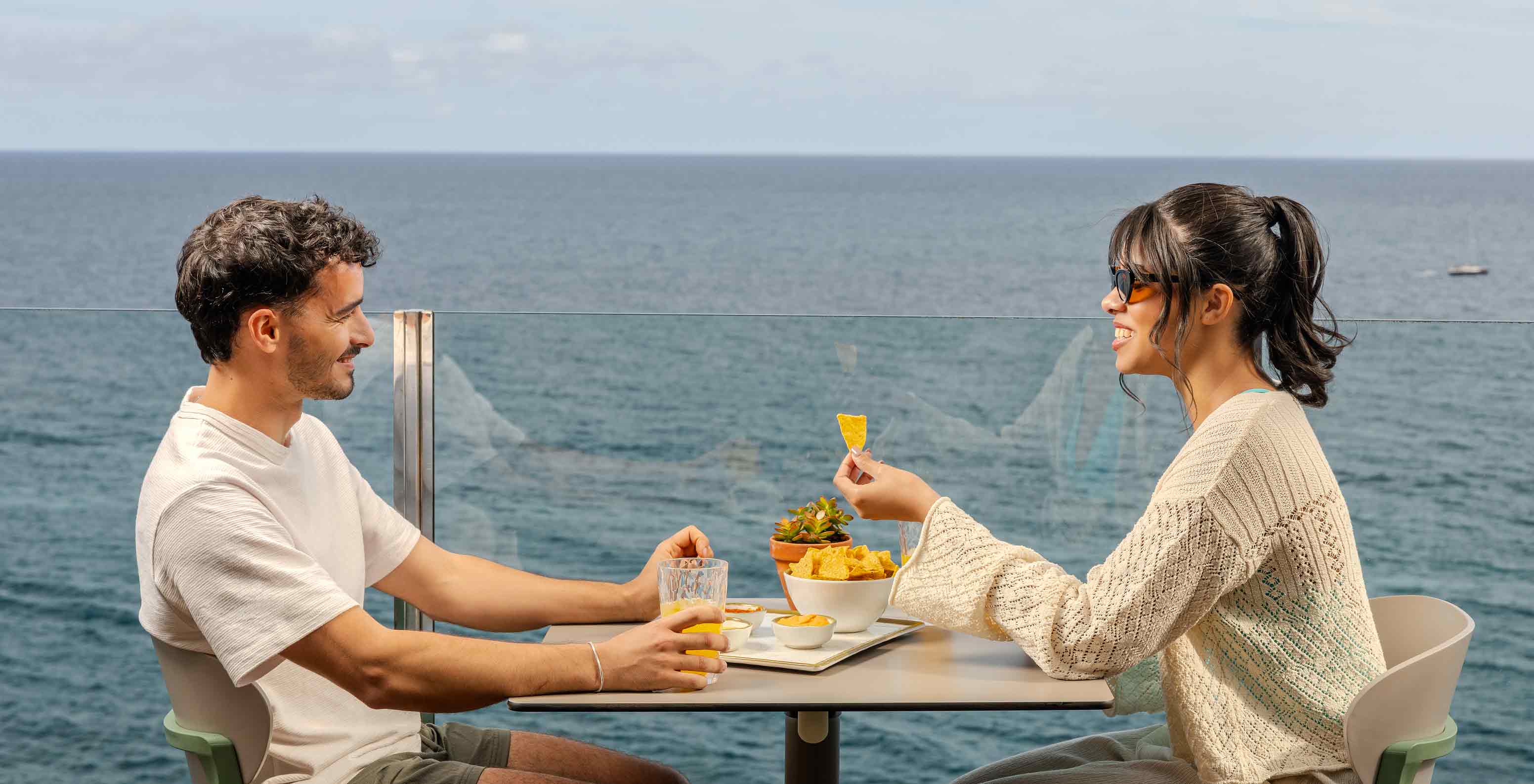 Pestana Carlton Madeira Hotel 5 Estrelas na Madeira, terraço junto ao mar com casal a partilhar snacks