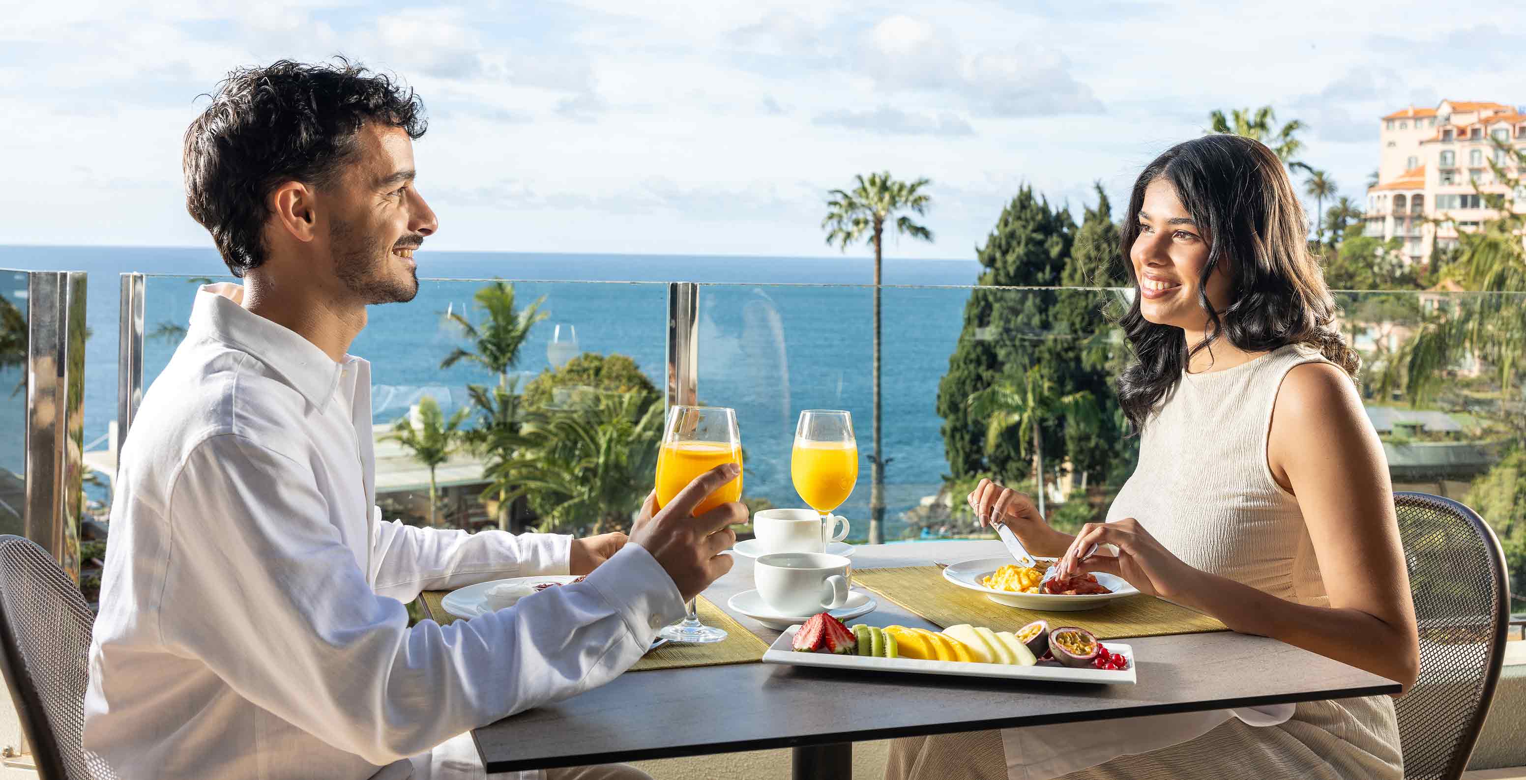 Pestana Carlton Madeira Hotel 5 Estrelas na Madeira, casal toma pequeno-almoço num terraço com vista mar