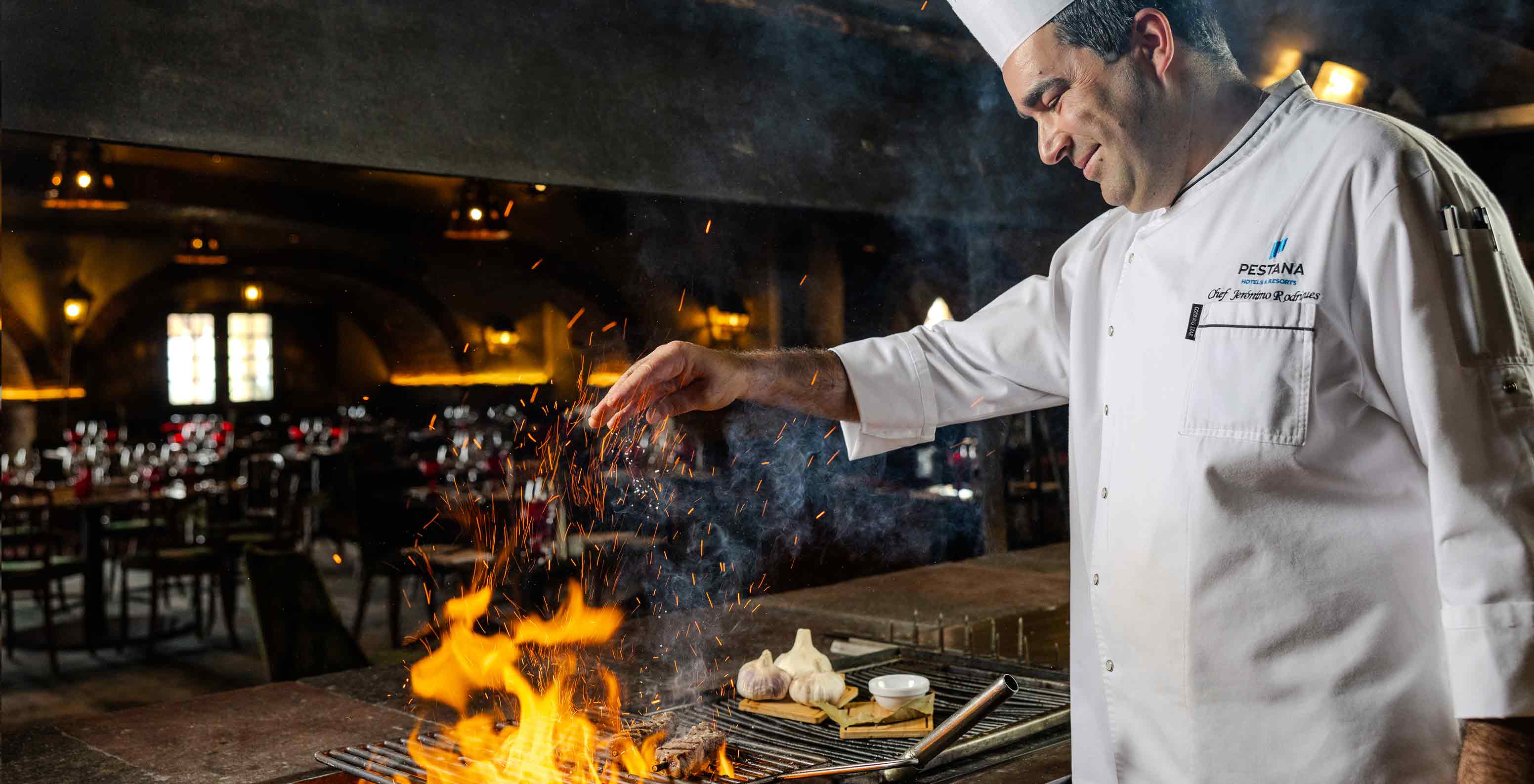 Pestana Carlton Madeira, Hotel 5 Estrelas na Madeira, com chef a preparar carne na grelha em fogo aberto