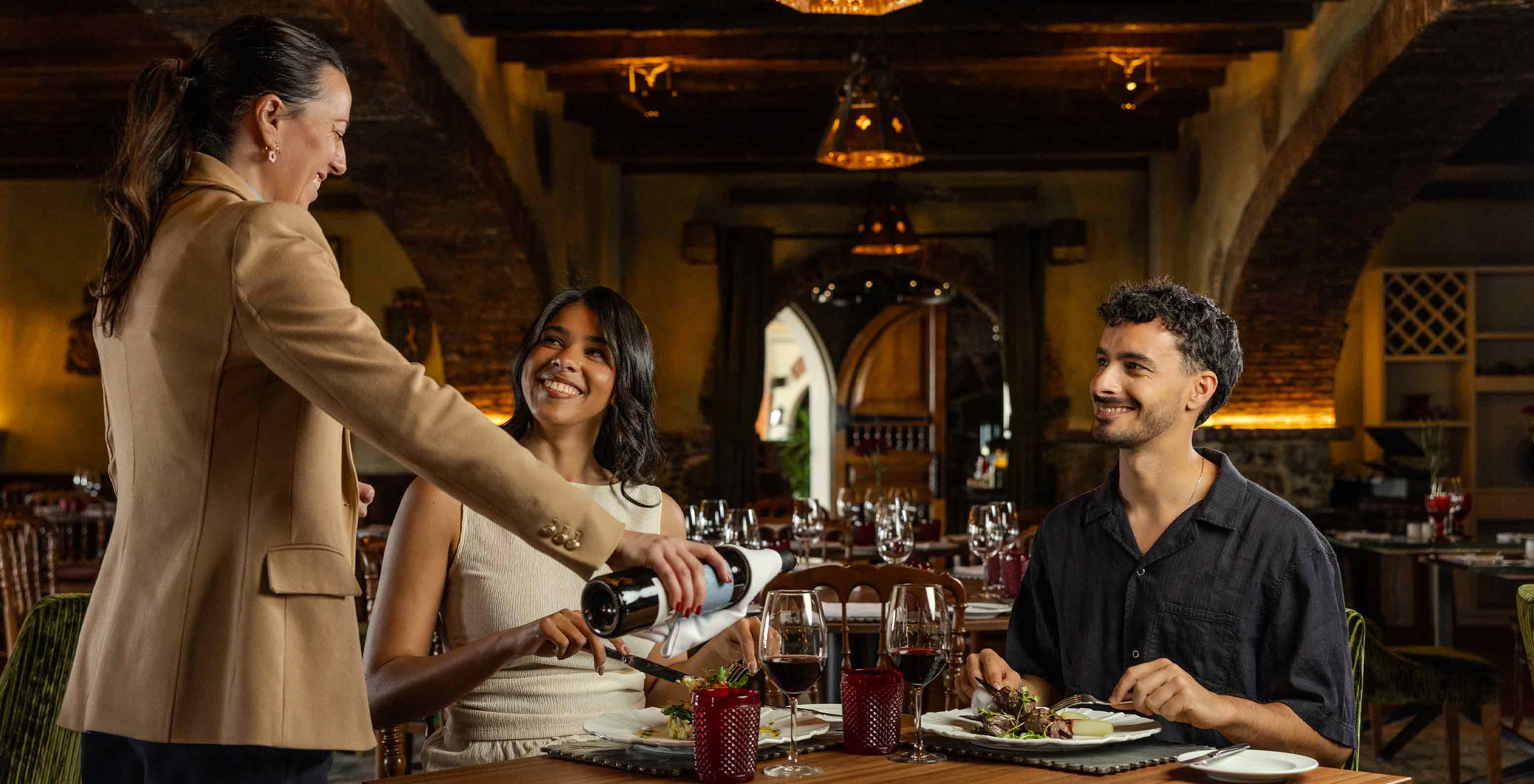 Pestana Carlton Madeira Hotel 5 Estrelas na Madeira, casal janta num restaurante rústico com vinho tinto