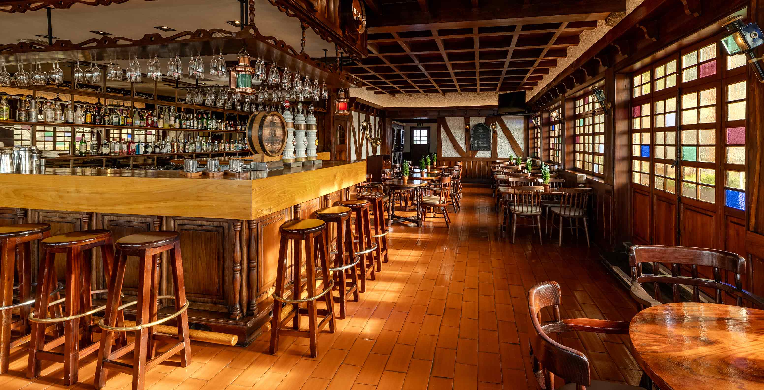 Pestana Carlton Madeira, Hotel 5 Estrelas na Madeira, com pub de madeira escura e balcão iluminado ao fundo