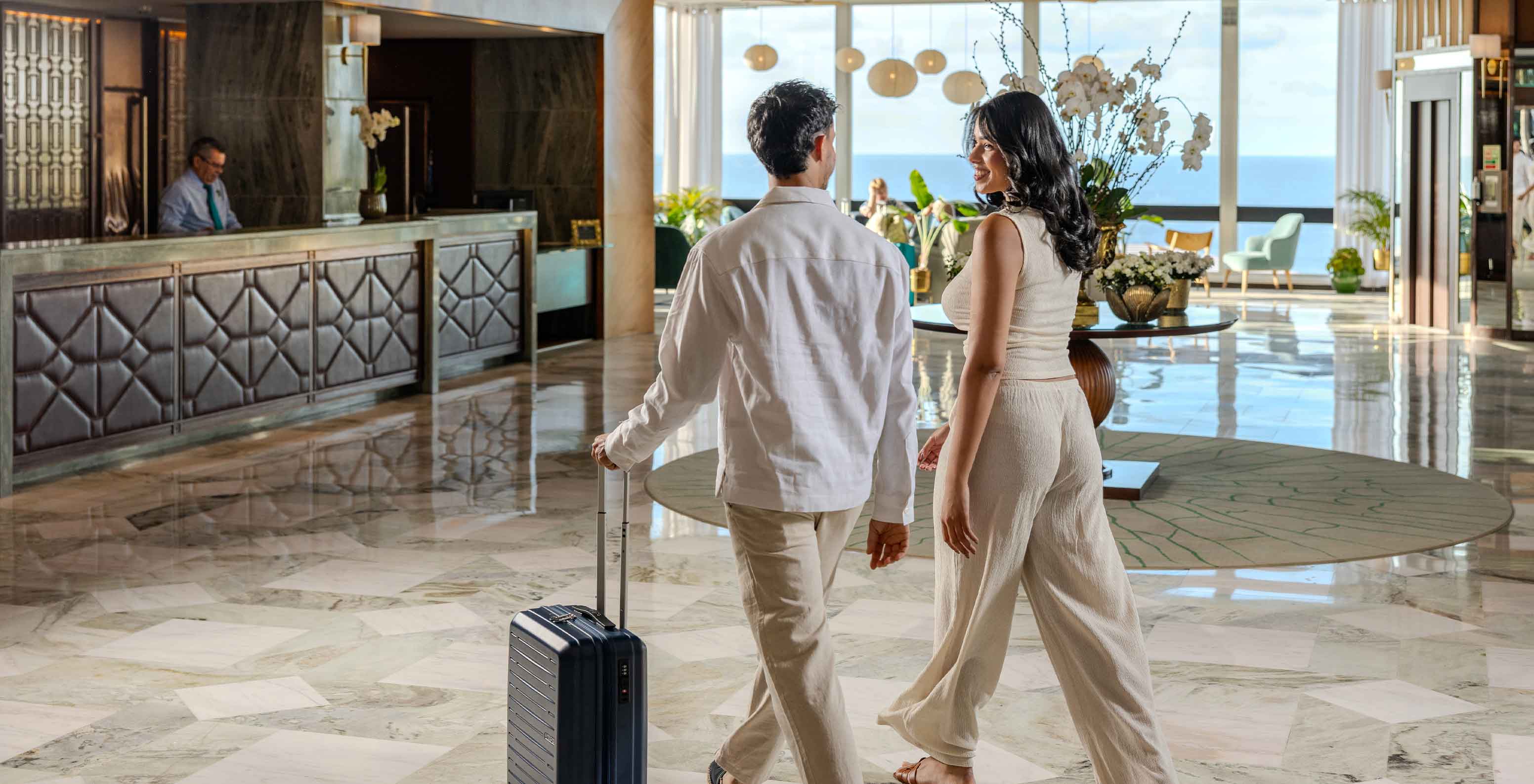 Pestana Carlton Madeira, Hotel 5 Estrelas na Madeira, lobby luminosa com hóspedes e vista mar ao fundo