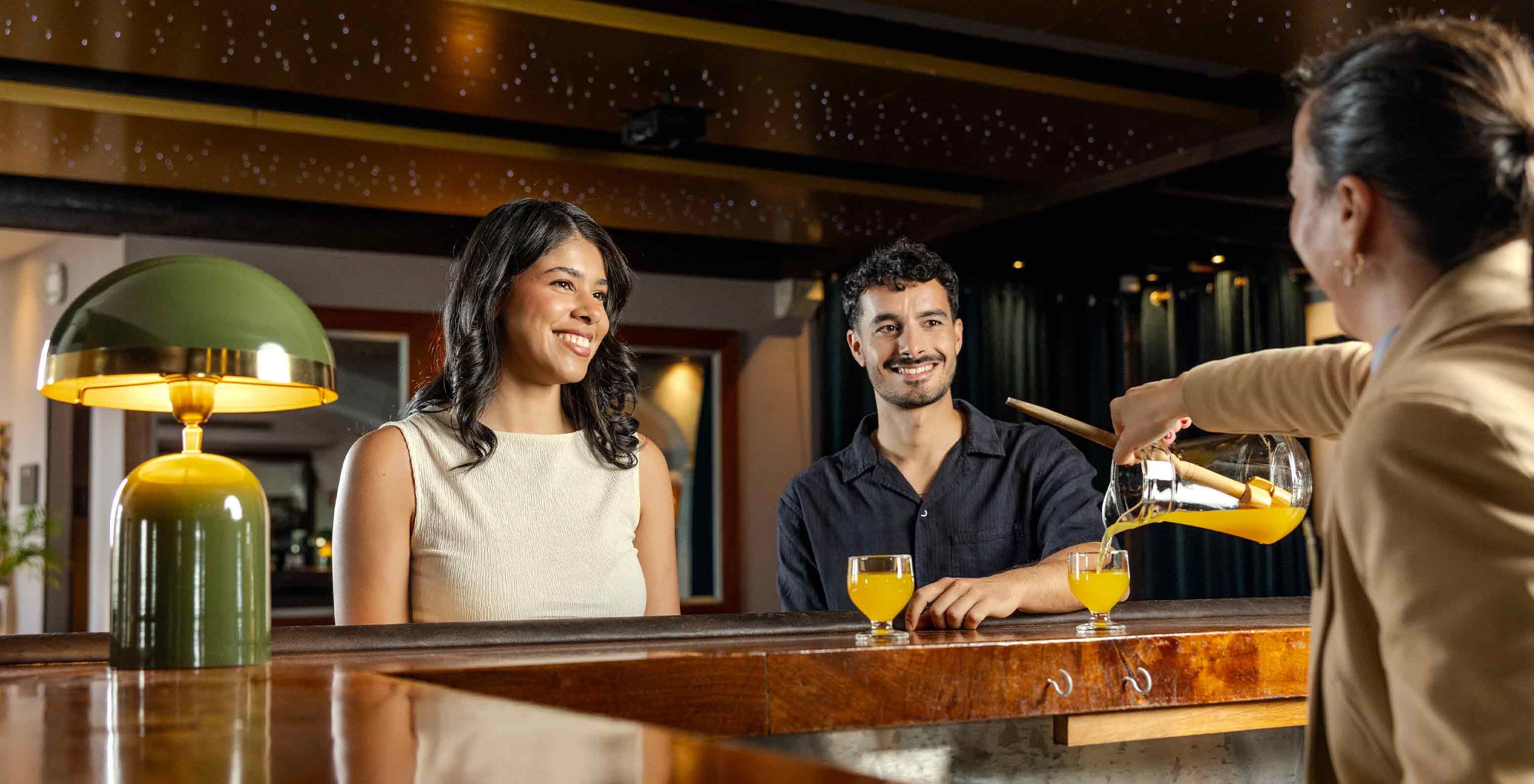 Bar do Pestana Carlton Madeira, Hotel 5 Estrelas na Madeira com hóspedes junto ao balcão e bebidas servidas