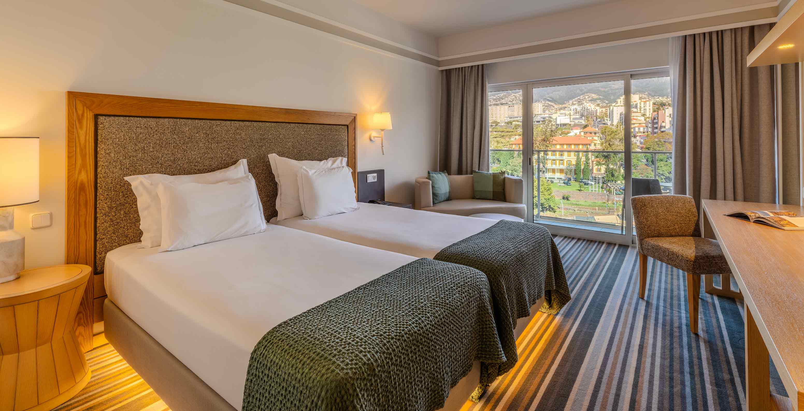 Quarto Clássico Vista Cidade no Pestana Carlton Madeira com camas individuais e varanda sobre a cidade