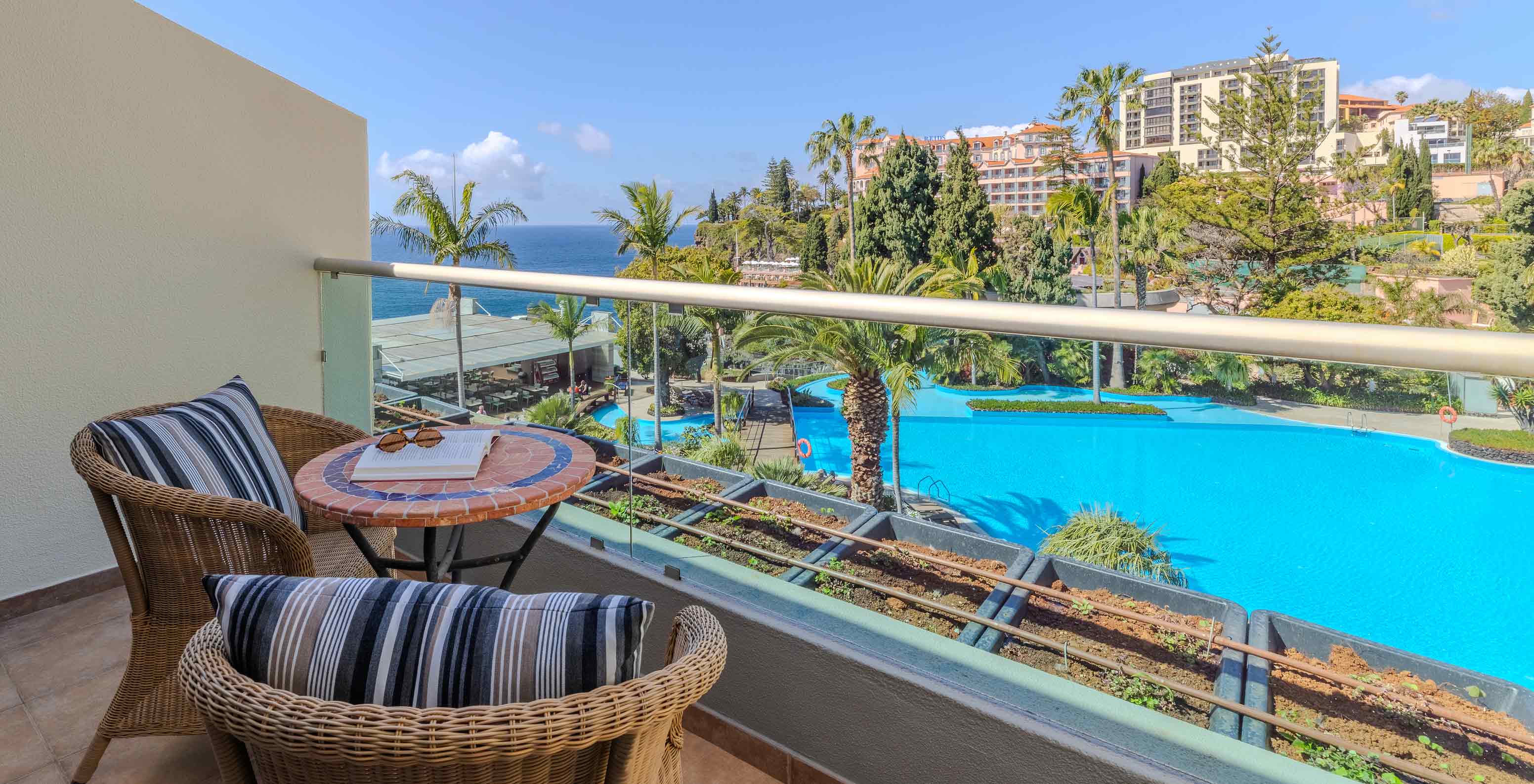 Suite Júnior no Pestana Carlton Madeira com varanda mobilada e vista para piscina tropical e oceano