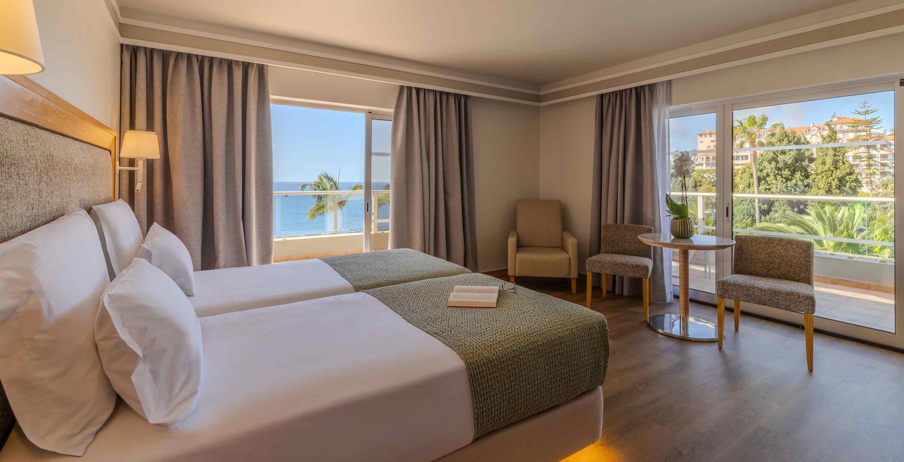Suite Júnior no Pestana Carlton Madeira com camas individuais e varanda com vista para o mar e jardins