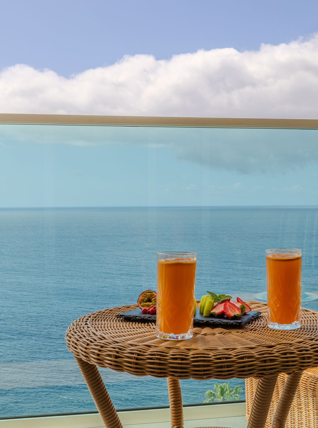 Suite Júnior Superior no Pestana Carlton Madeira com varanda sobre o mar, mesa com bebidas e vista costeira