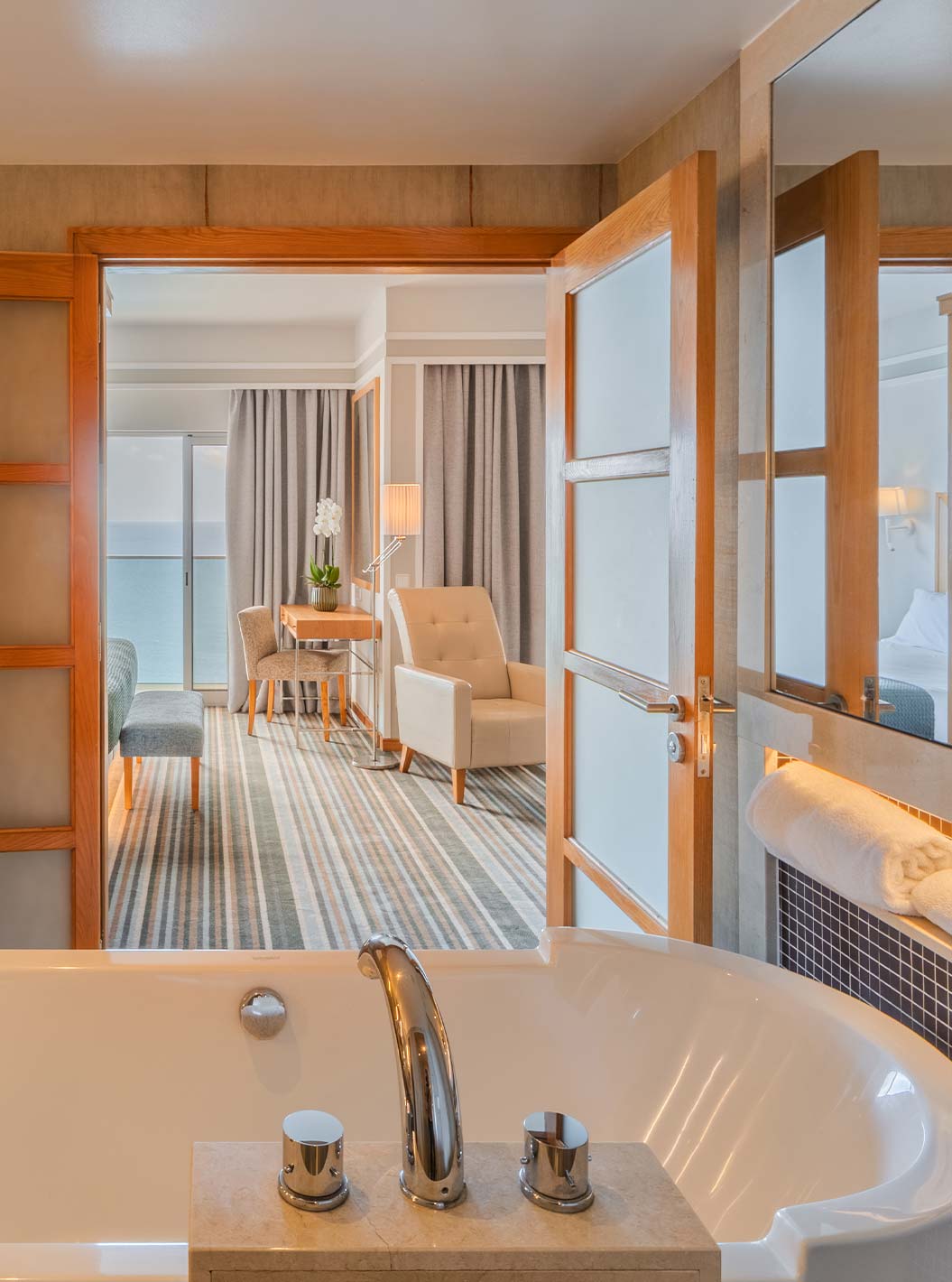 Suite Júnior Superior no Pestana Carlton Madeira com banheira ampla e vista para a área de estar luminosa