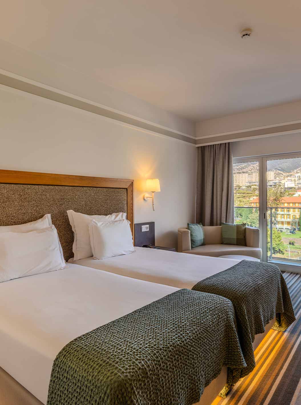 Quarto Twin Clássico Vista Cidade no Pestana Carlton Madeira com duas camas e varanda voltada para a cidade