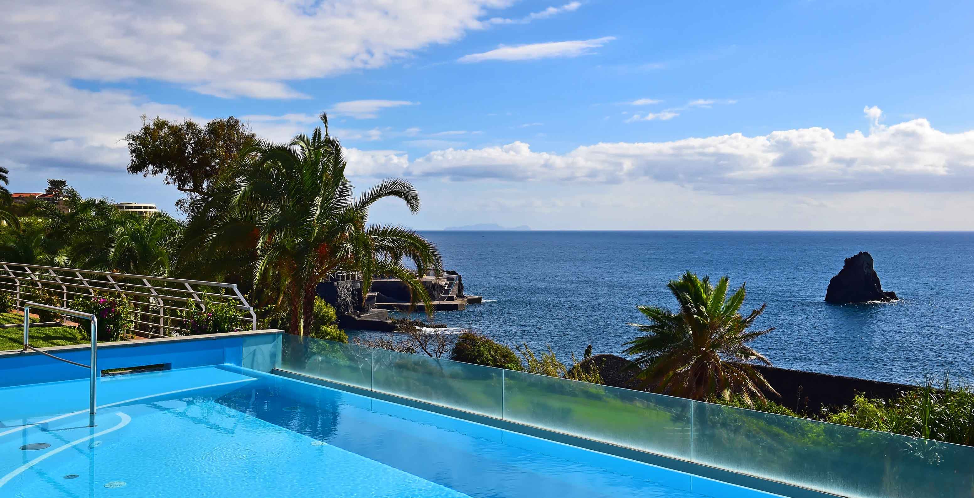 Piscina exterior infinita do Pestana Promenade, Hotel na Madeira, Perto da Praia e do Lido, com vista para o mar e palmeiras